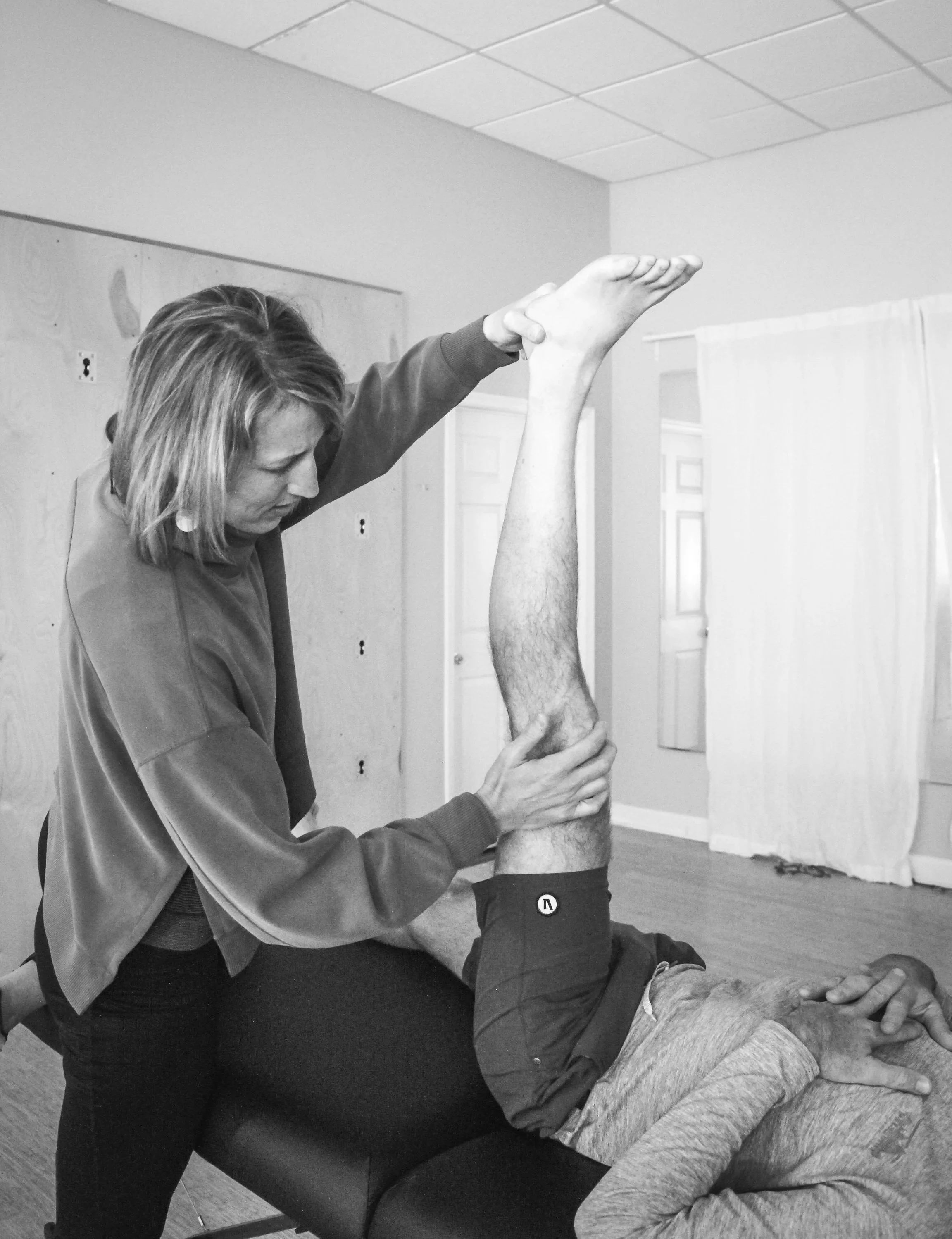 A physical therapist in Charlottesville, VA working on a patient's knee hip mobility