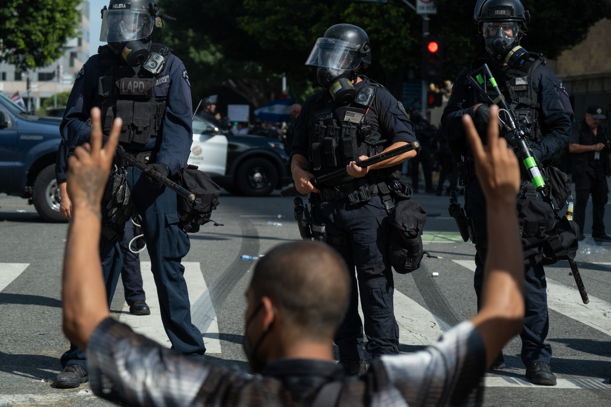 A demonstrator peacefully protests in front of the Los Angeles Police Department minutes after being tear-gassed during the No Kings Protest, downtown Los Angeles, June 14, 2025.