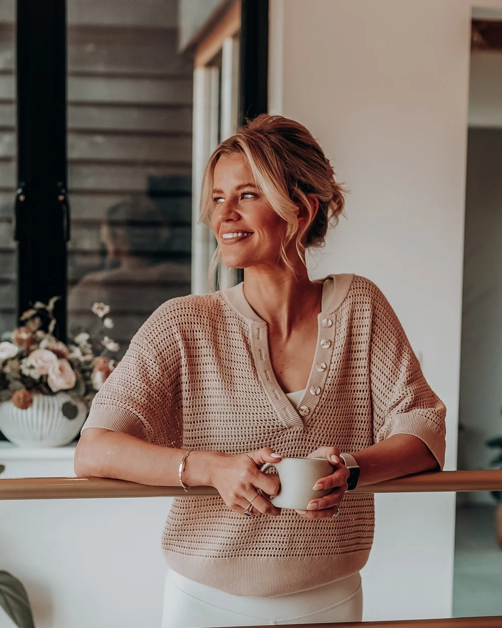 Gen, founder of The Barre Coach, at the barre with a coffee