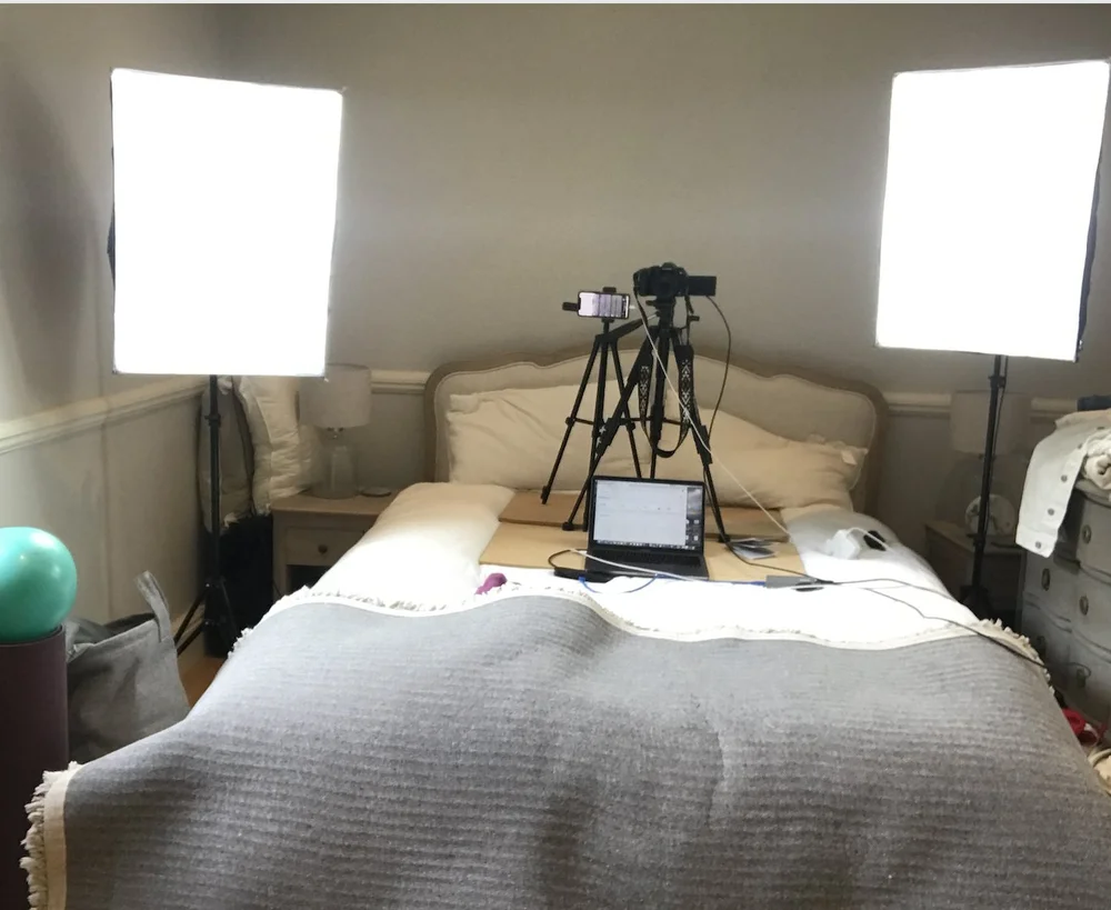 Gen's old spare room setup with lights, tripods and a laptop on the bed