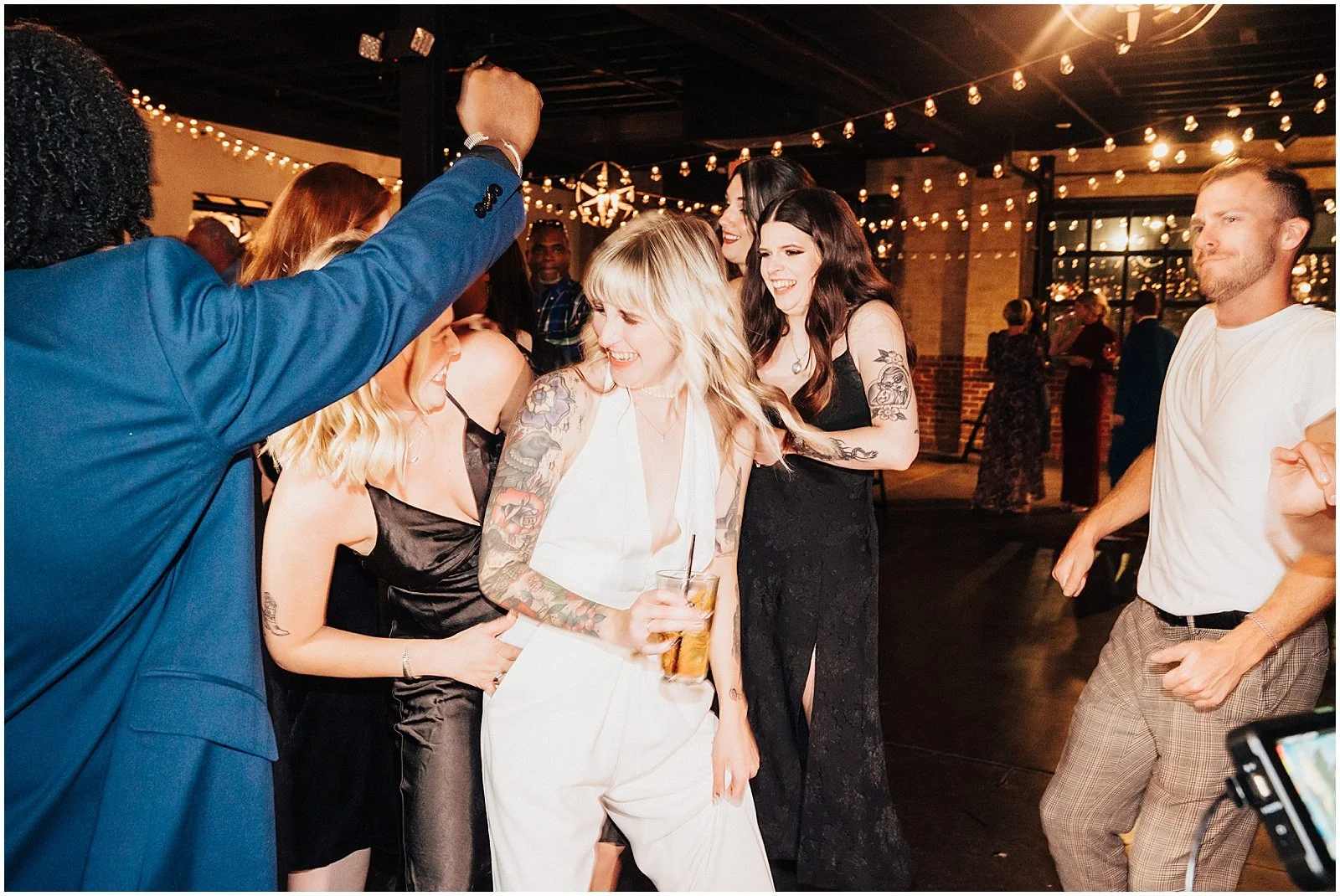 Wedding guests garther around a bride on a dance floor.