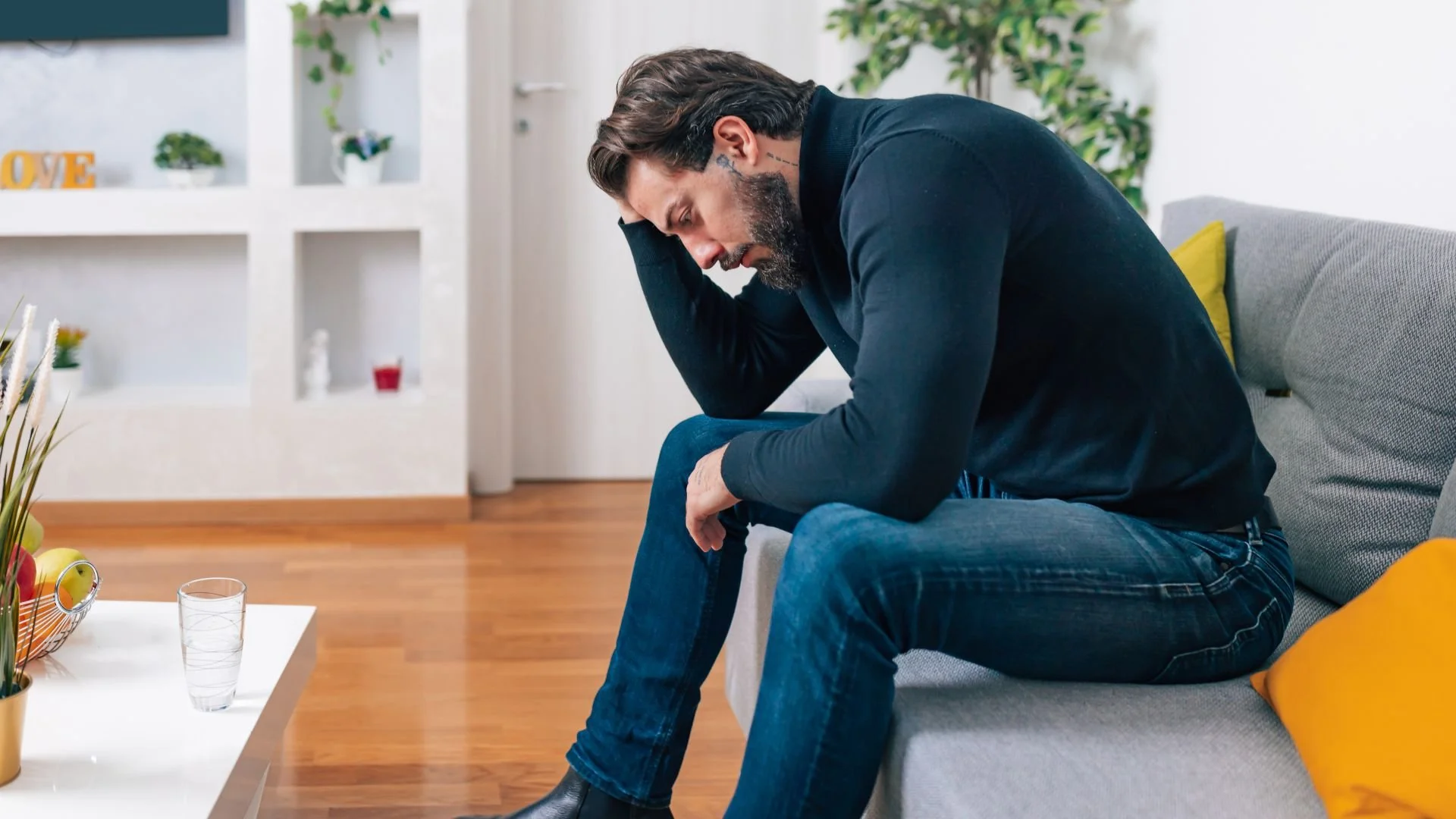 A distressed man holding his head in his hands, representing someone seeking EMDR therapy for depression and anxiety.