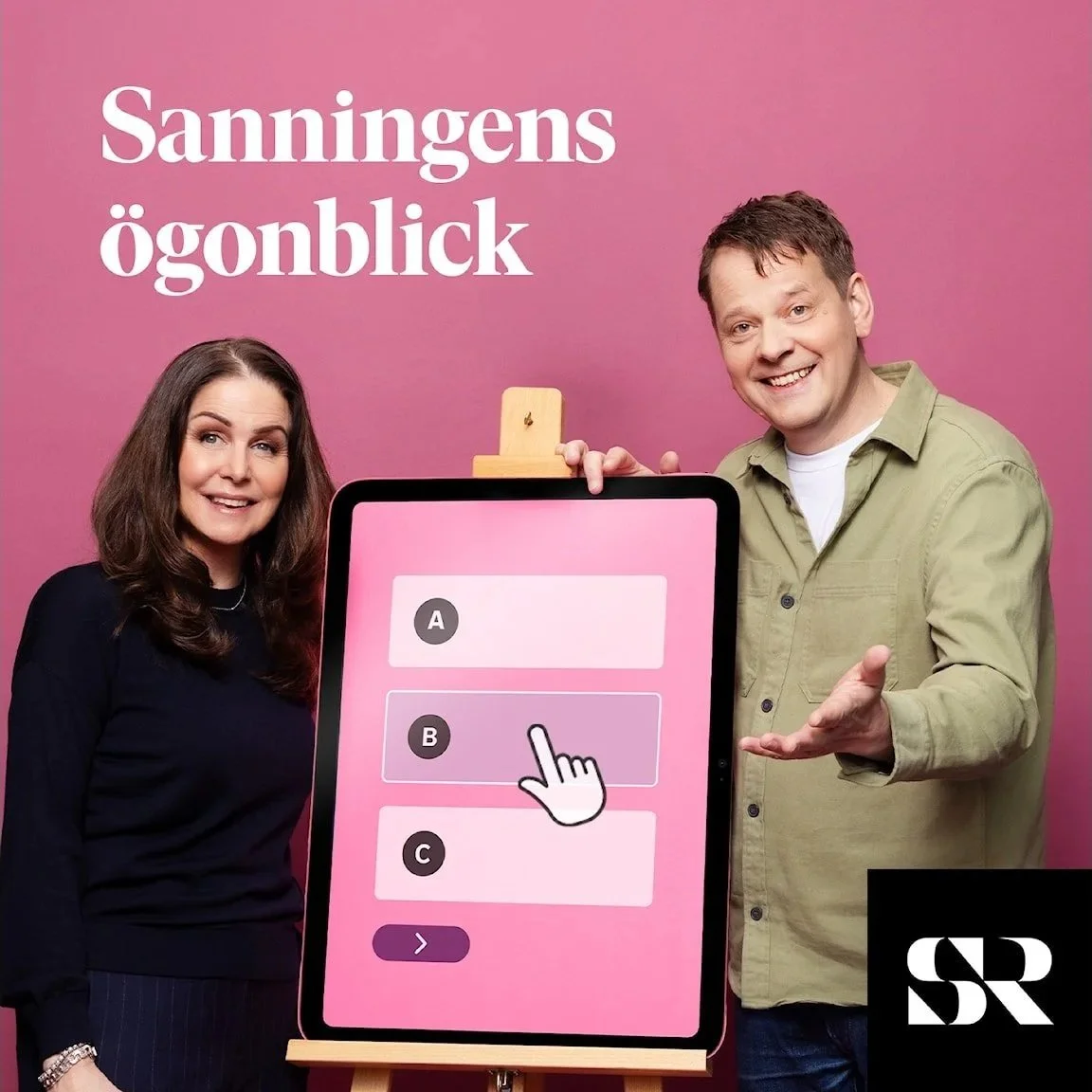 Two smiling people, a woman and a man, standing beside a large tablet displaying a multiple-choice question with options A, B, and C, with B highlighted and a cursor pointing at it. The background is pink with German text that reads 'Sanningens ögonblick' and a black square with white initials SR.