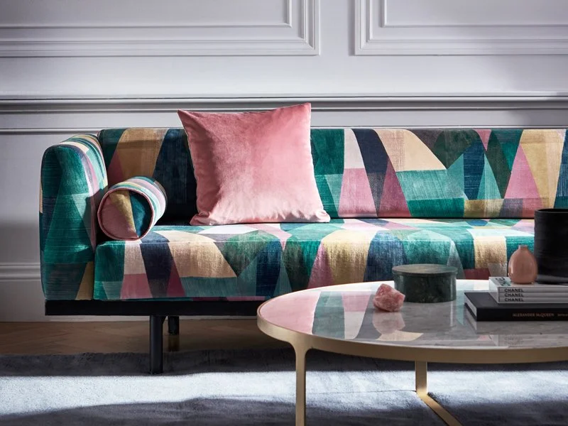 Farger i interiør inspirasjon av Lise S Studio. Grafiske former med farger, rosa, grønt, oransje   på sofa og pute.
