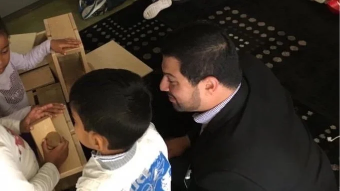 Jeremy Wittet playing wooden blocks with school children