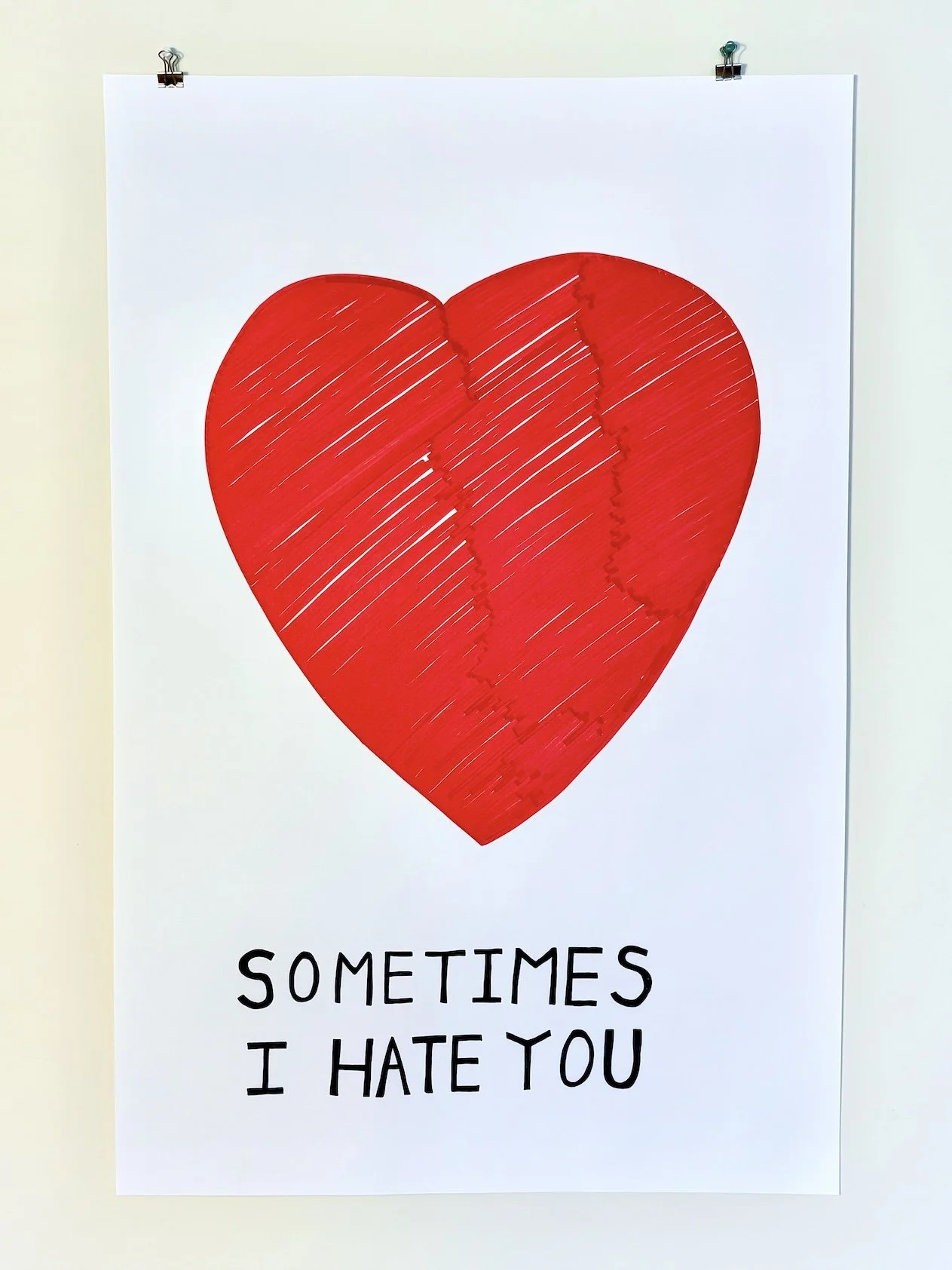 A white poster featuring a large red, torn heart with the text "Sometimes I hate you" written below it.