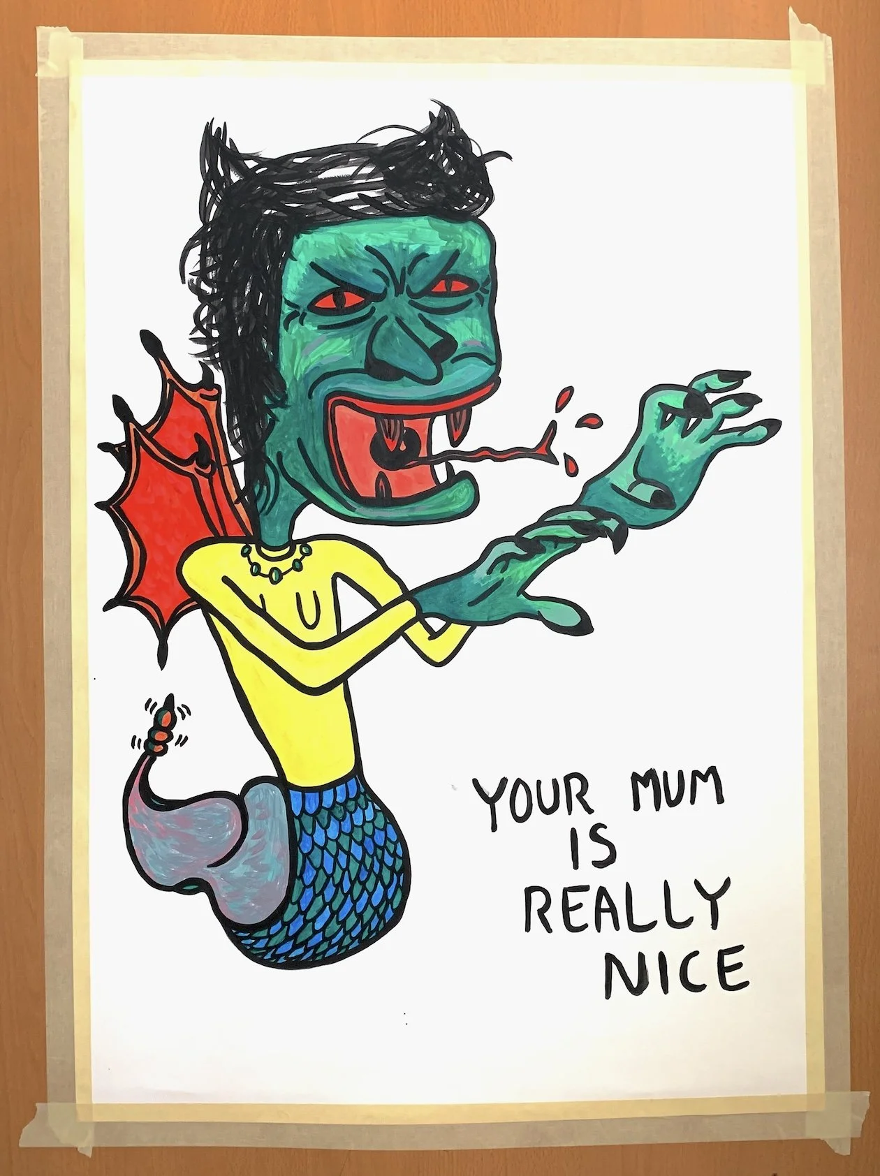 A colorful drawing of a green-skinned, humanoid creature with a fish-like tail, black spiky hair, red eyes, and vampire fangs. It has red, bat-like wings and is wearing a yellow top with a necklace. The creature is sticking out its tongue and has claws. Next to it, handwritten text reads, "Your mum is really nice."