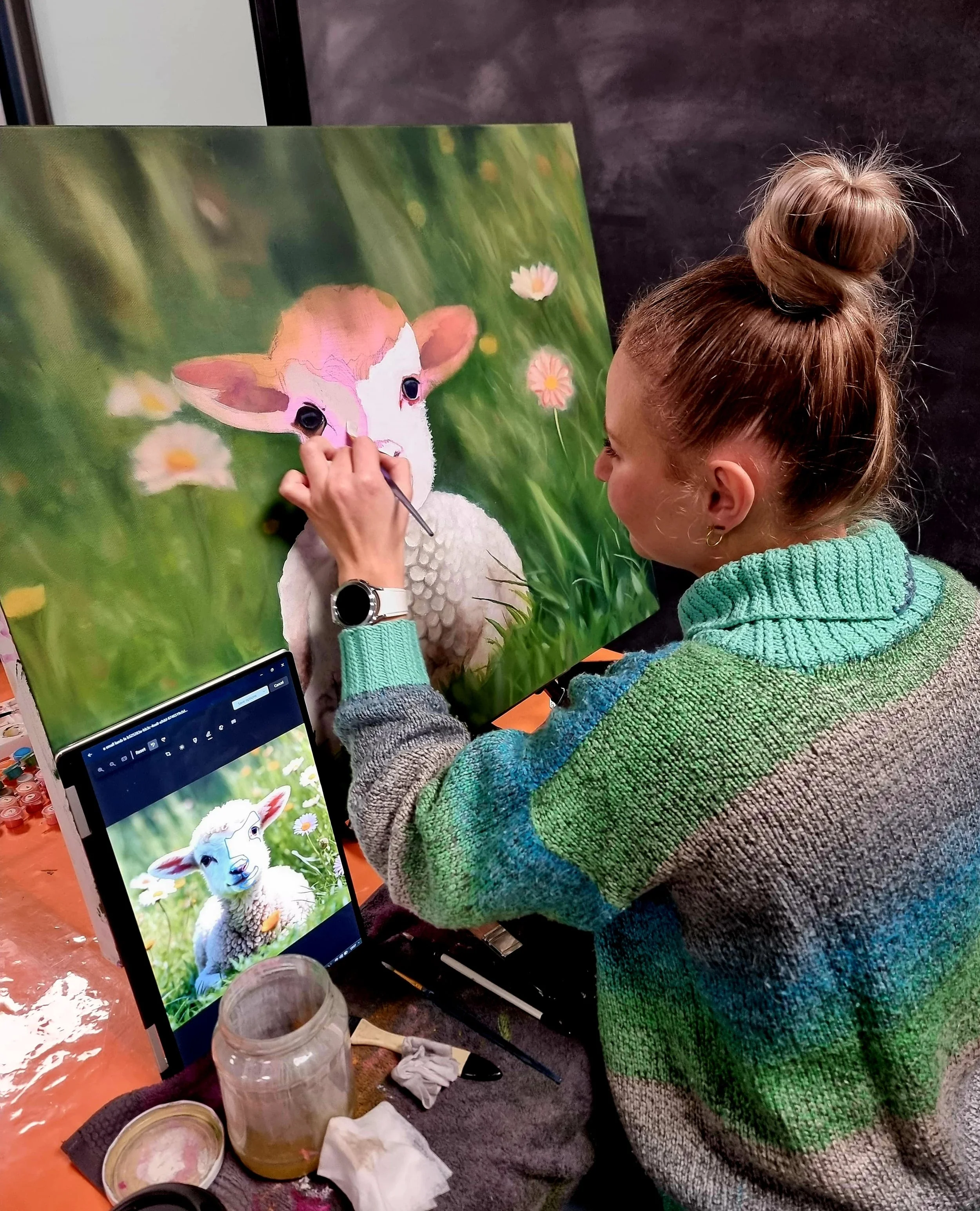 An artist painting a realistic image of a lamb on a canvas with a reference photo on a tablet nearby. Adult beginner art classes near me