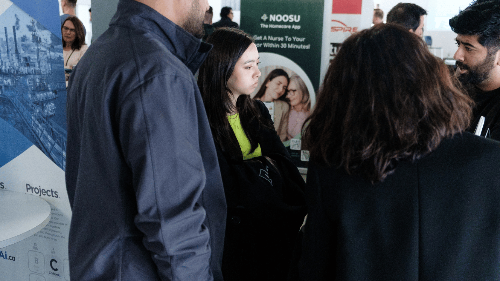 a woman looking at a demo of a product during the startup studio expo