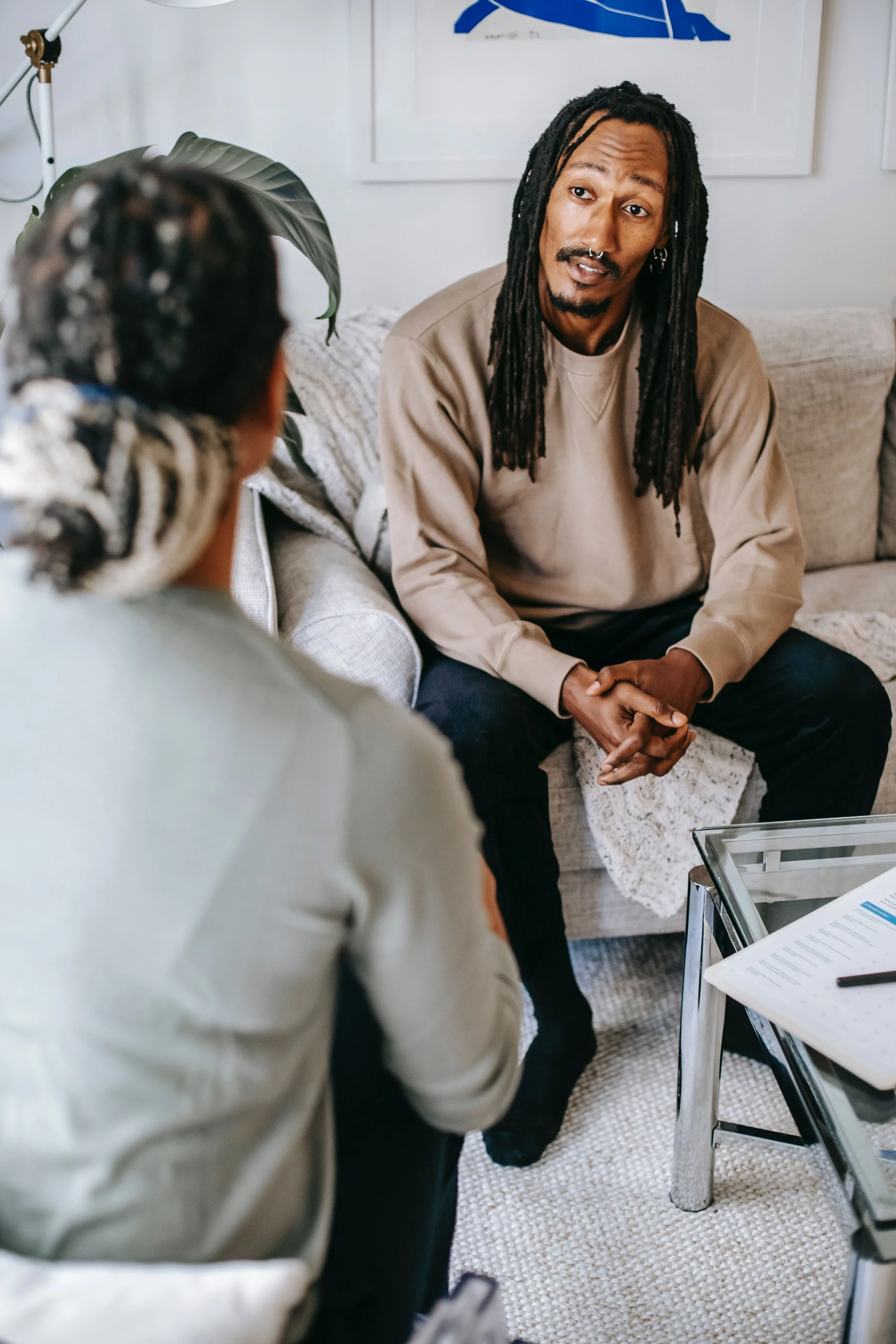 A black man with locs looking at a black woman