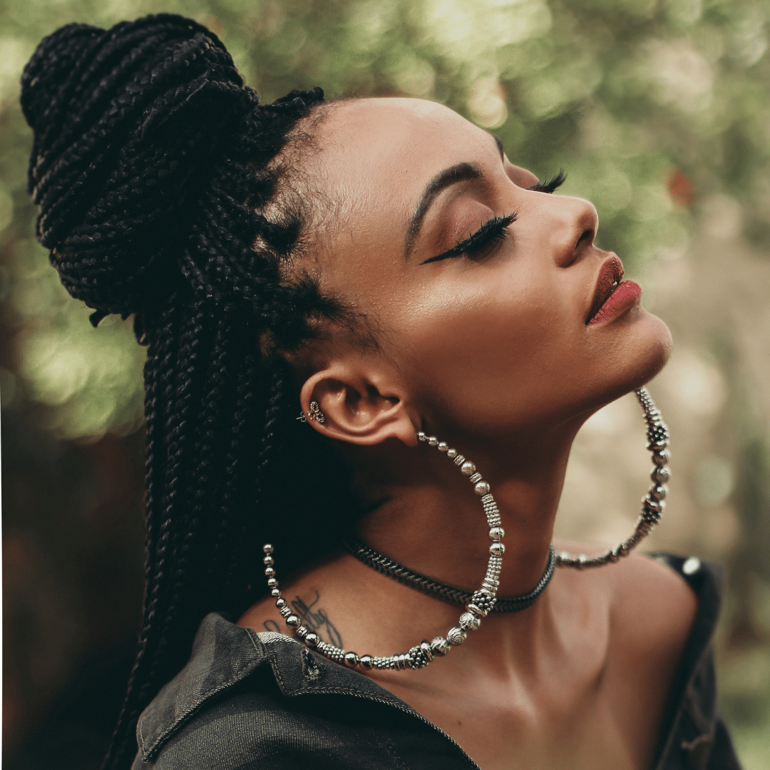 A black woman with braids meditating outside