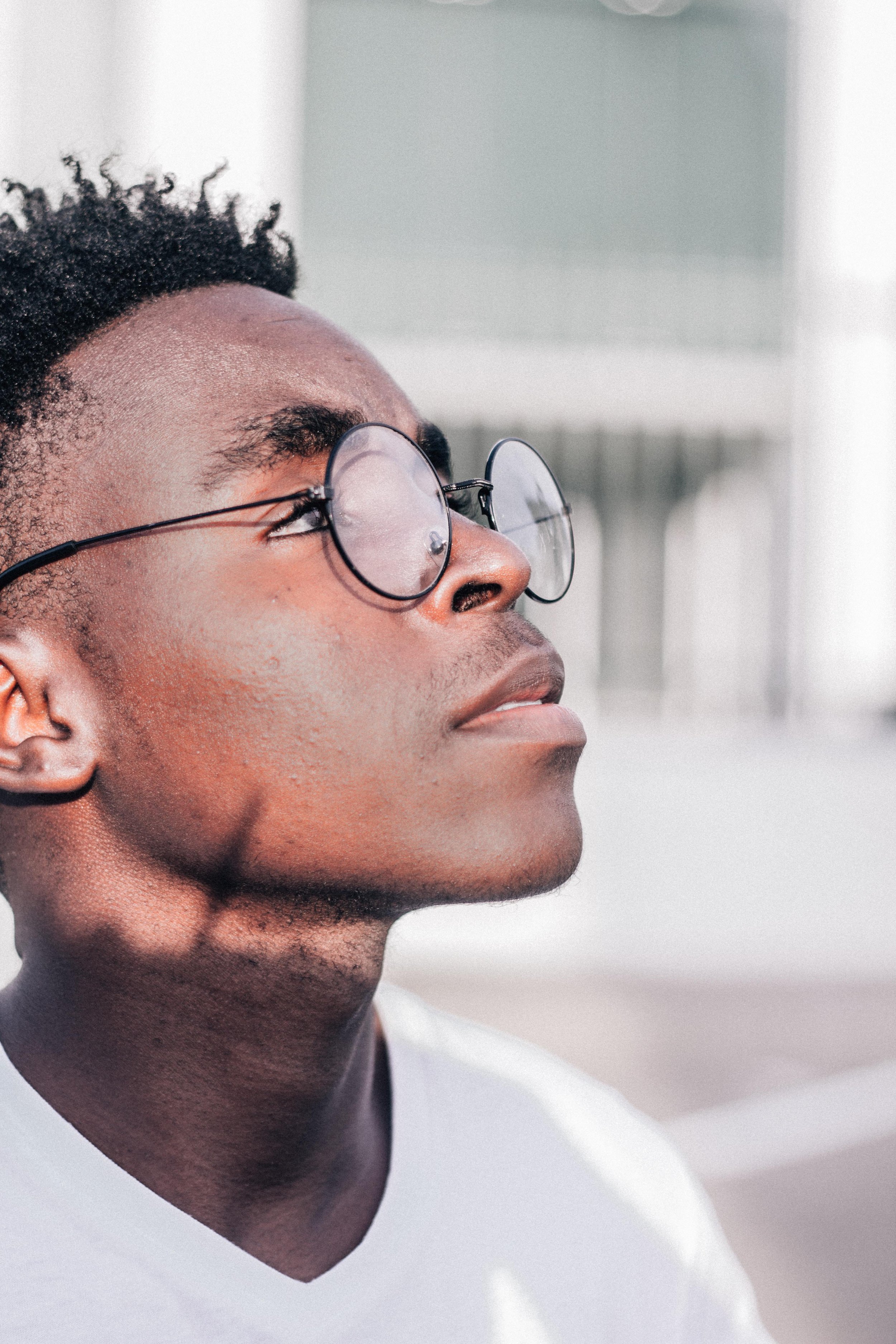 A black man with glasses looking at the sky