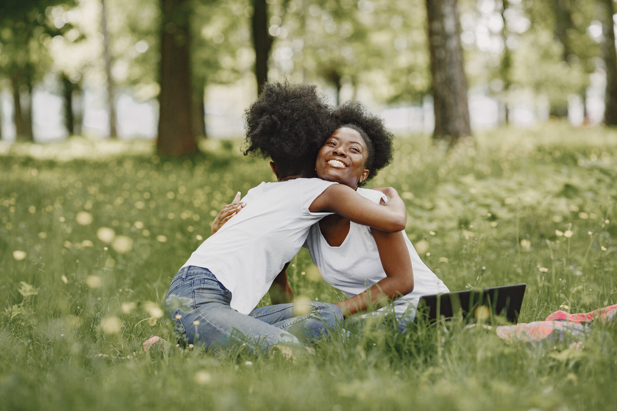Two black women hugging outside