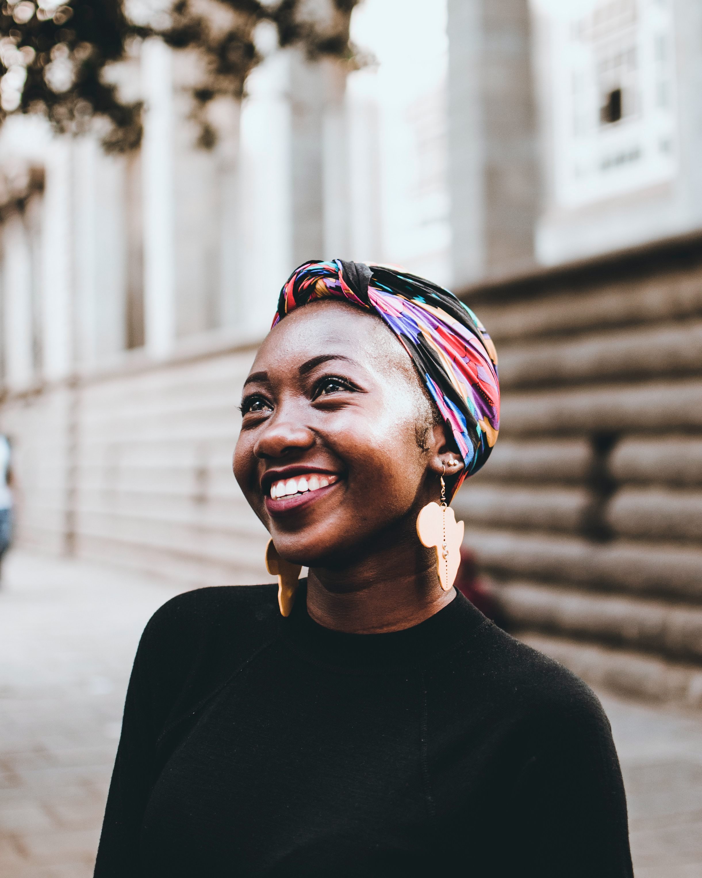 A black woman with a turban smiling.