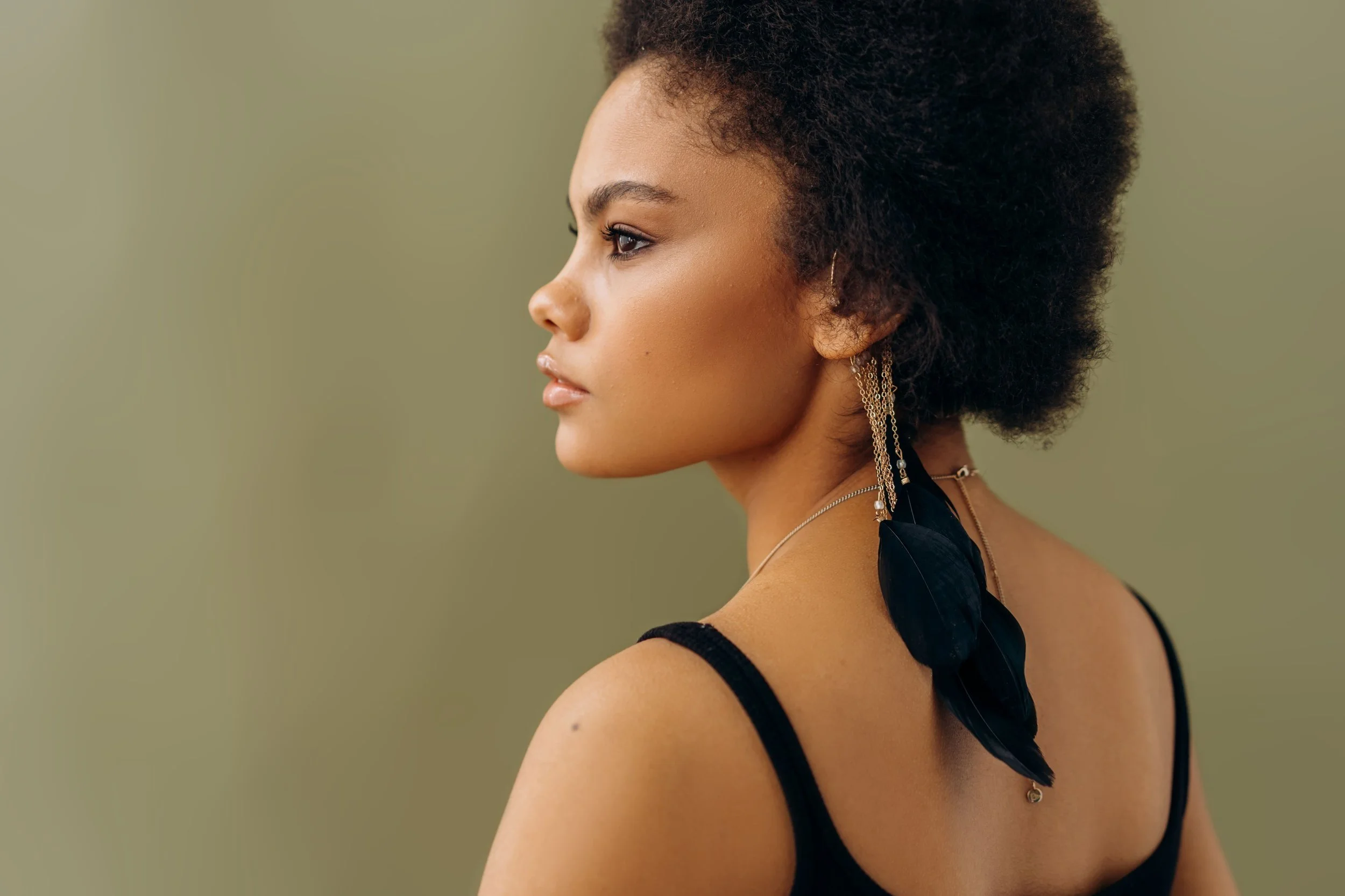A black woman with an afro looking out of a window.