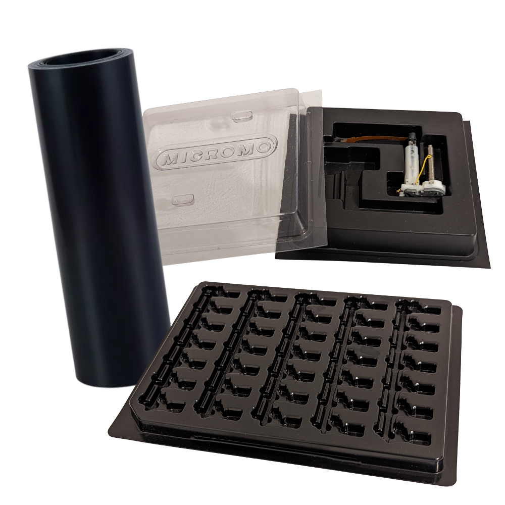 A silicone roller, a clear plastic container labeled 'MIGROMO', an open black box with electronic parts inside, and a black plastic tray with multiple small black clips or connectors.