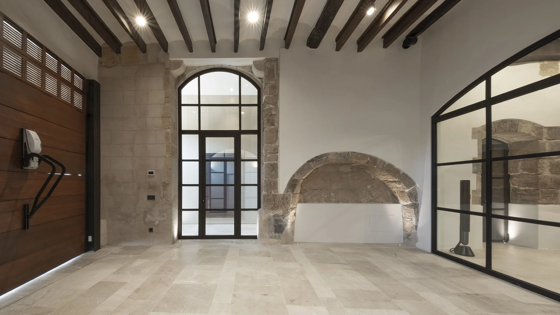 Restored stone walls, timber beams and arched glazing in Villa Calatrava entrance