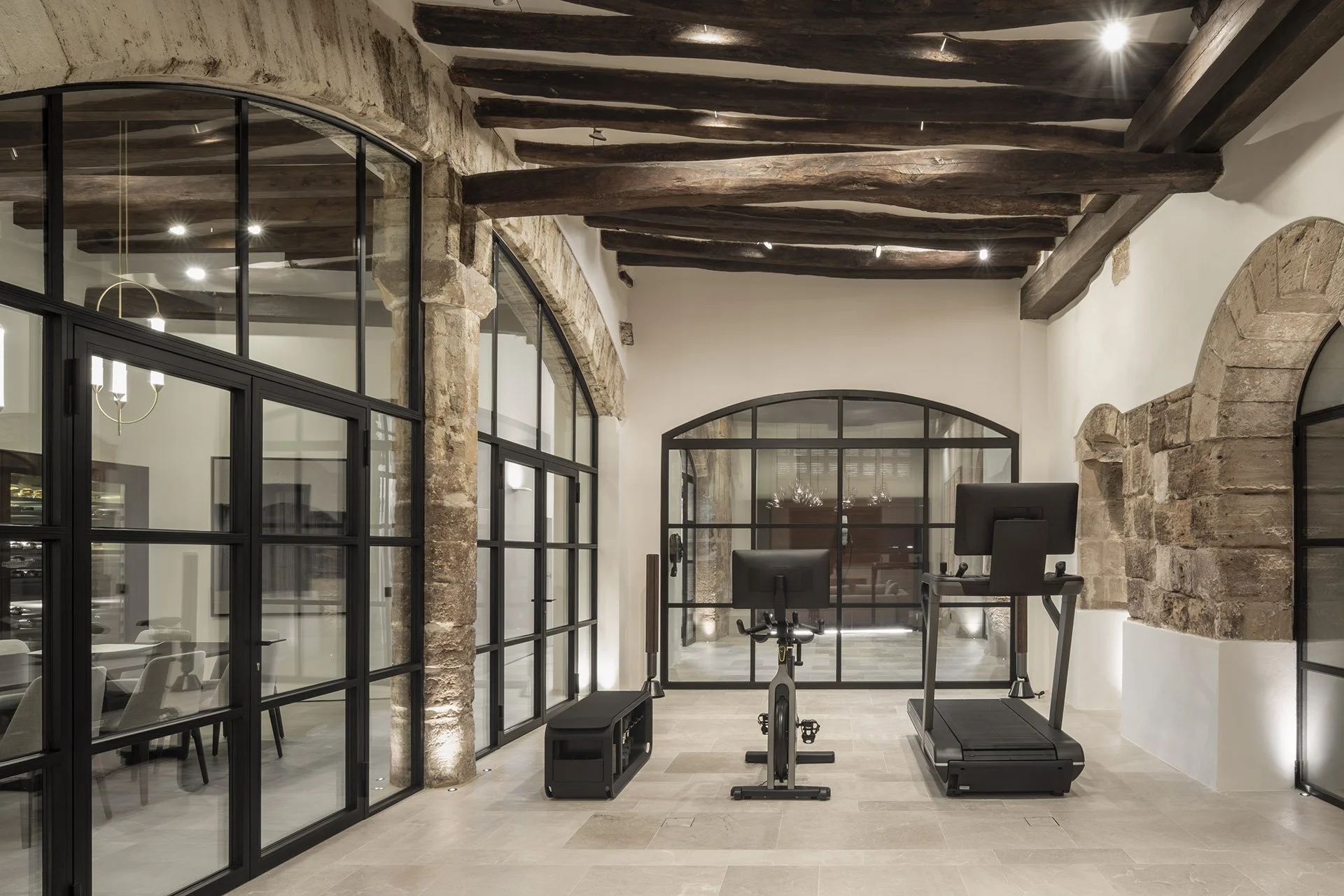 Private gym beneath restored timber beams at Villa Calatrava