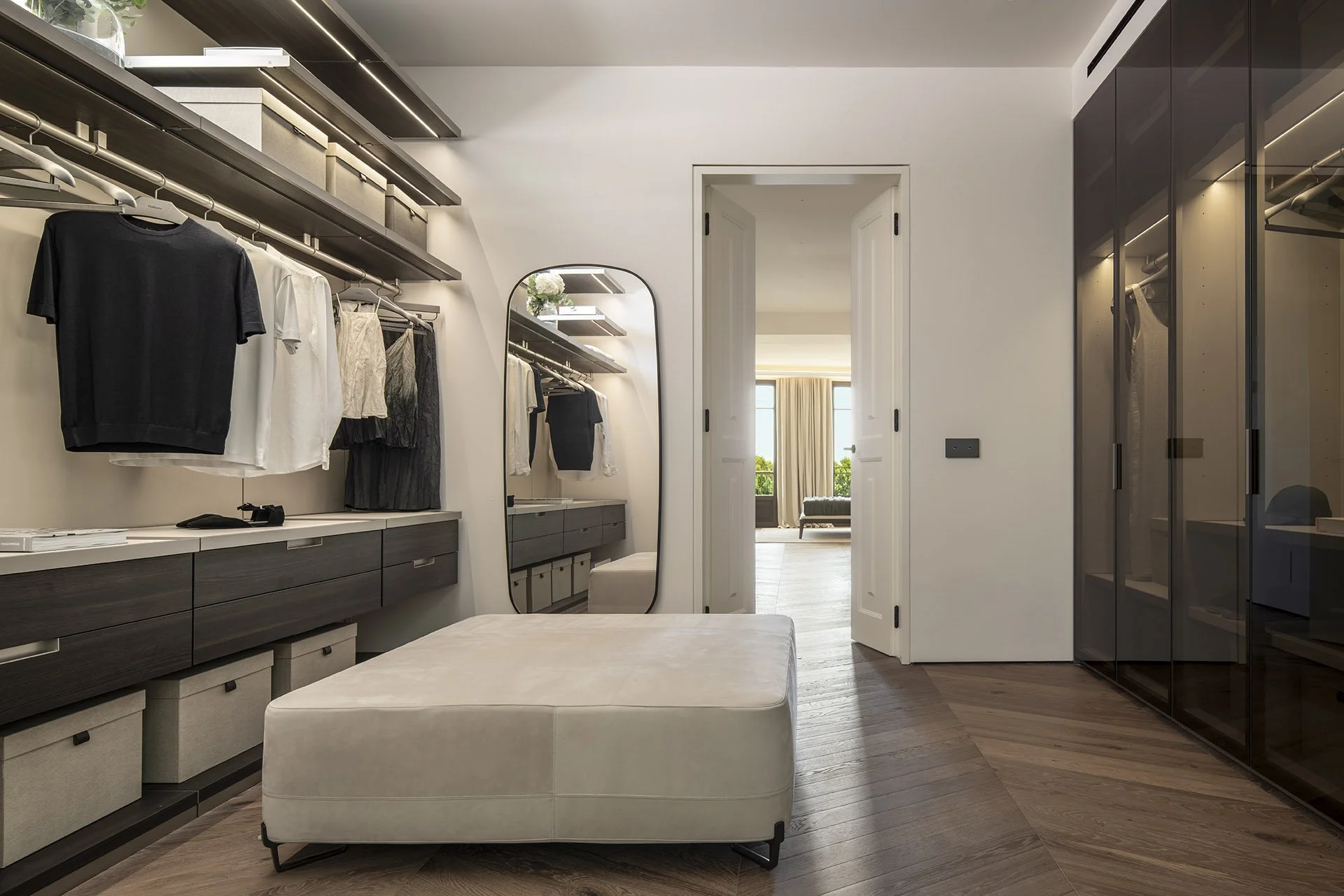 Dressing room with fitted wardrobes and central ottoman at Villa Calatrava