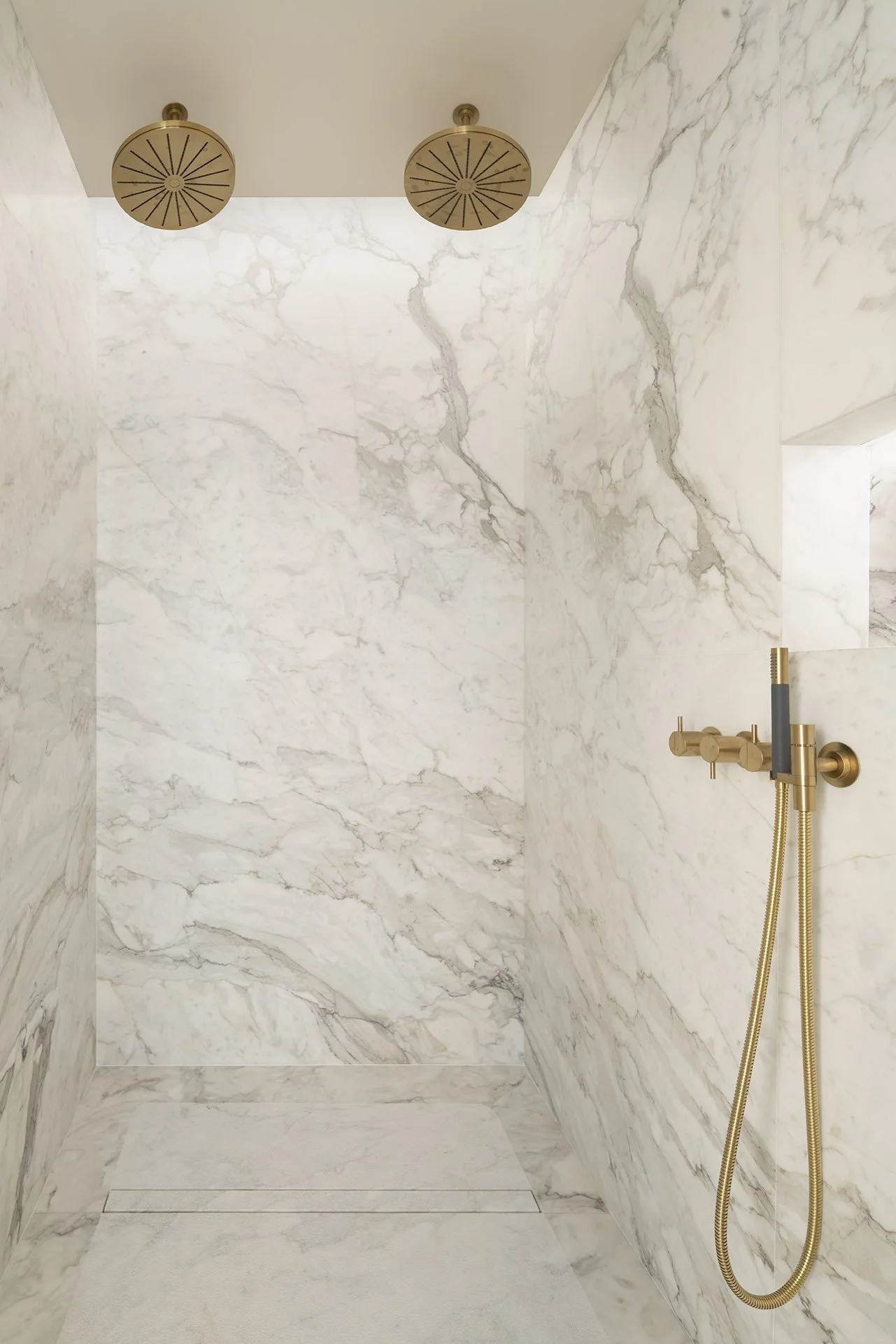 Twin brass rain showers and marble walls in the owner’s bathroom at Villa Calatrava