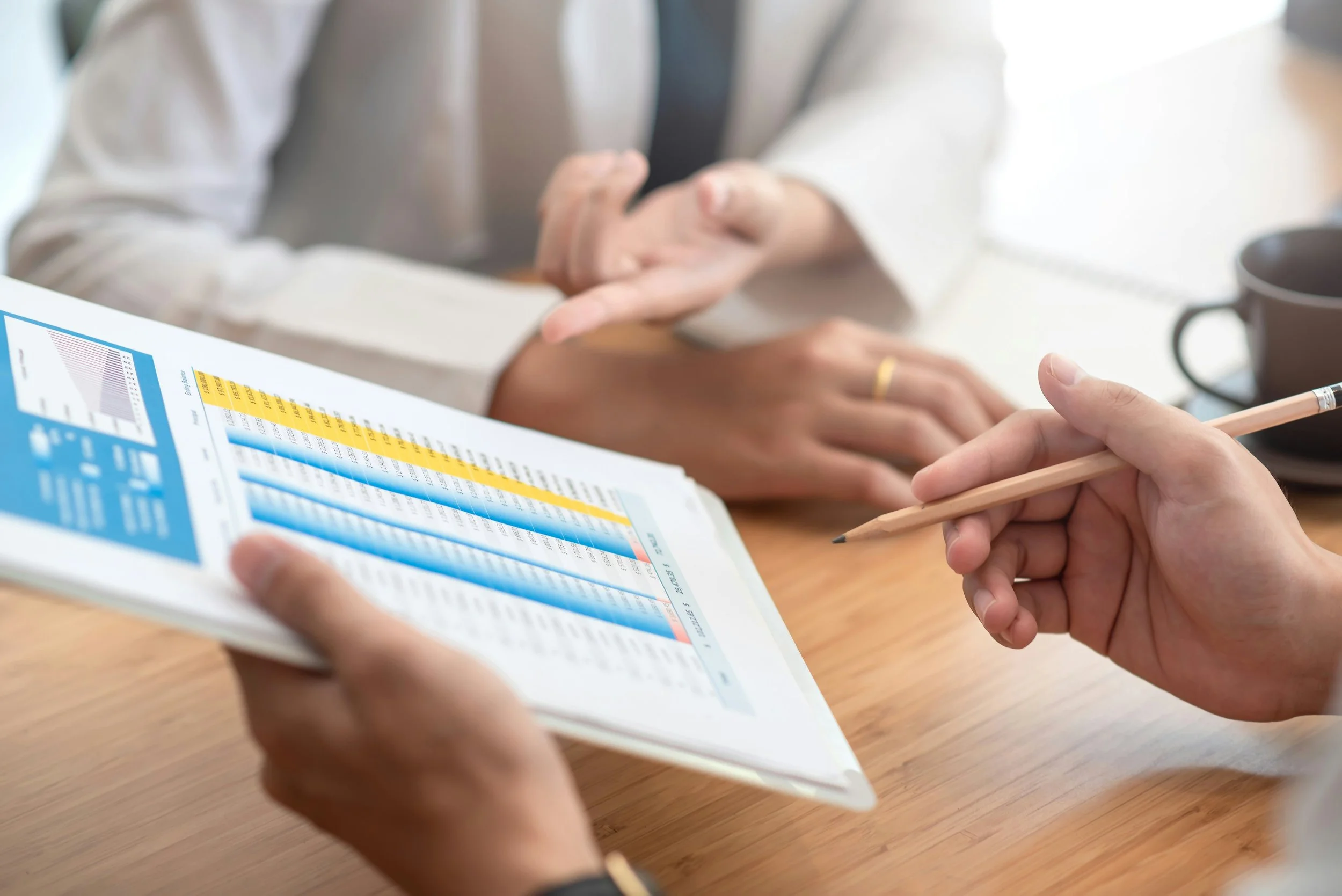 Two people reviewing a printed energy performance chart at a desk.