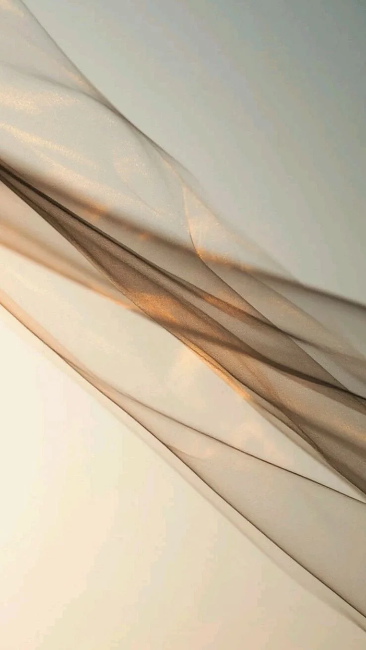 Close-up of layered, sheer, metallic and matte fabric with gold accents.