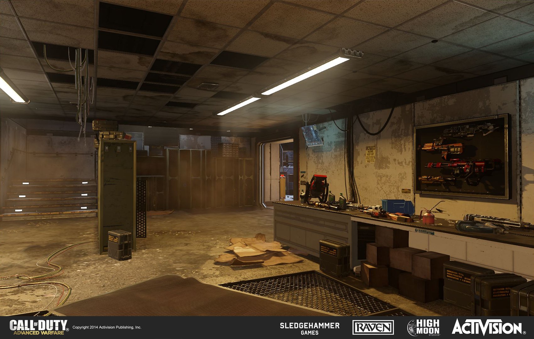An empty, slightly messy workshop or armory with a counter, tools, and weapon displays on the wall, and some cardboard on the floor. The room has a damaged ceiling and some bright fluorescent lights.