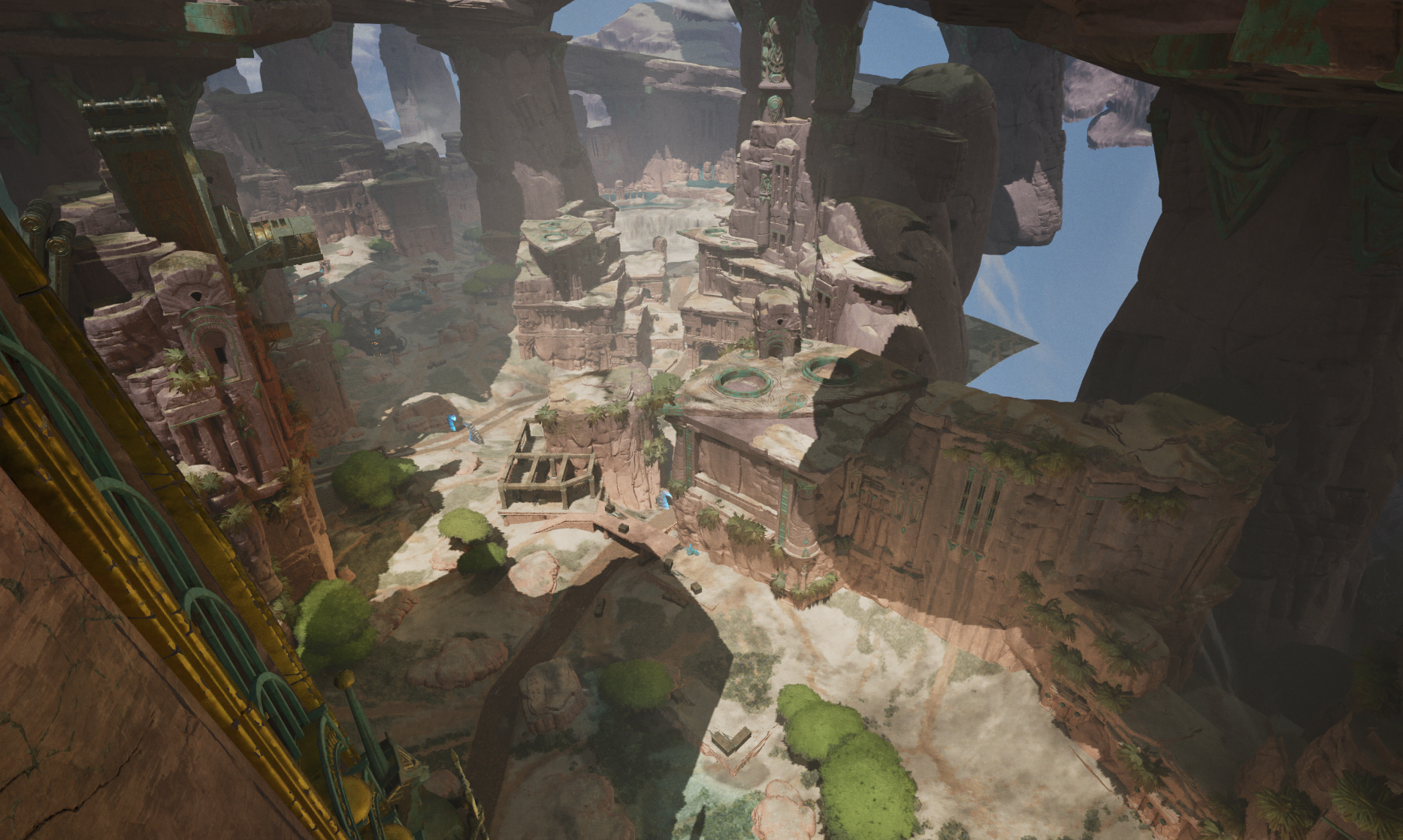 A vast, ancient canyon with towering rock formations and ruins, featuring pathways, trees, and waterfalls, with a bridge-like structure in the foreground.