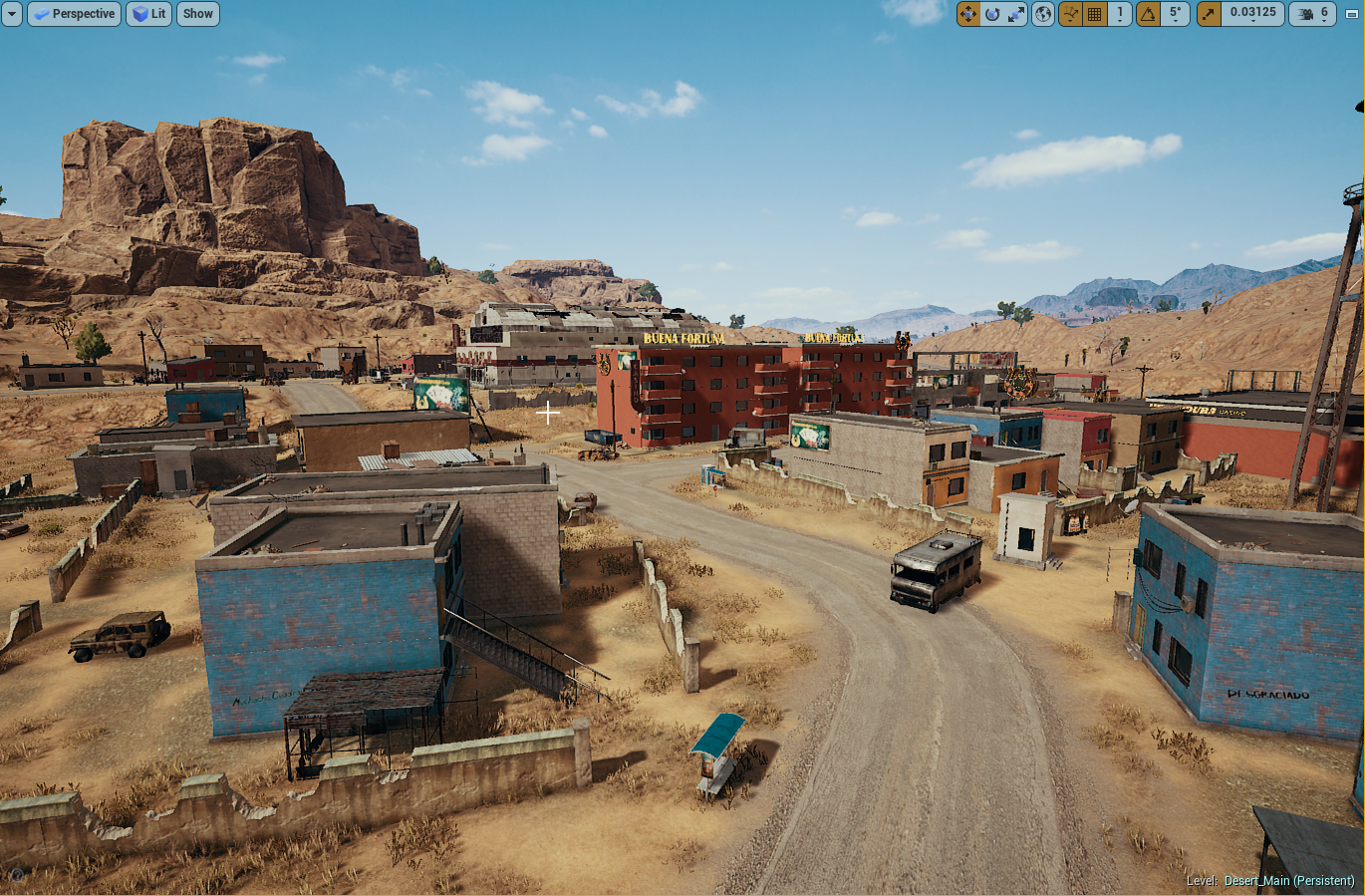A video game desert town with dirt roads, colorful buildings, rocky hills, and mountains in the background.