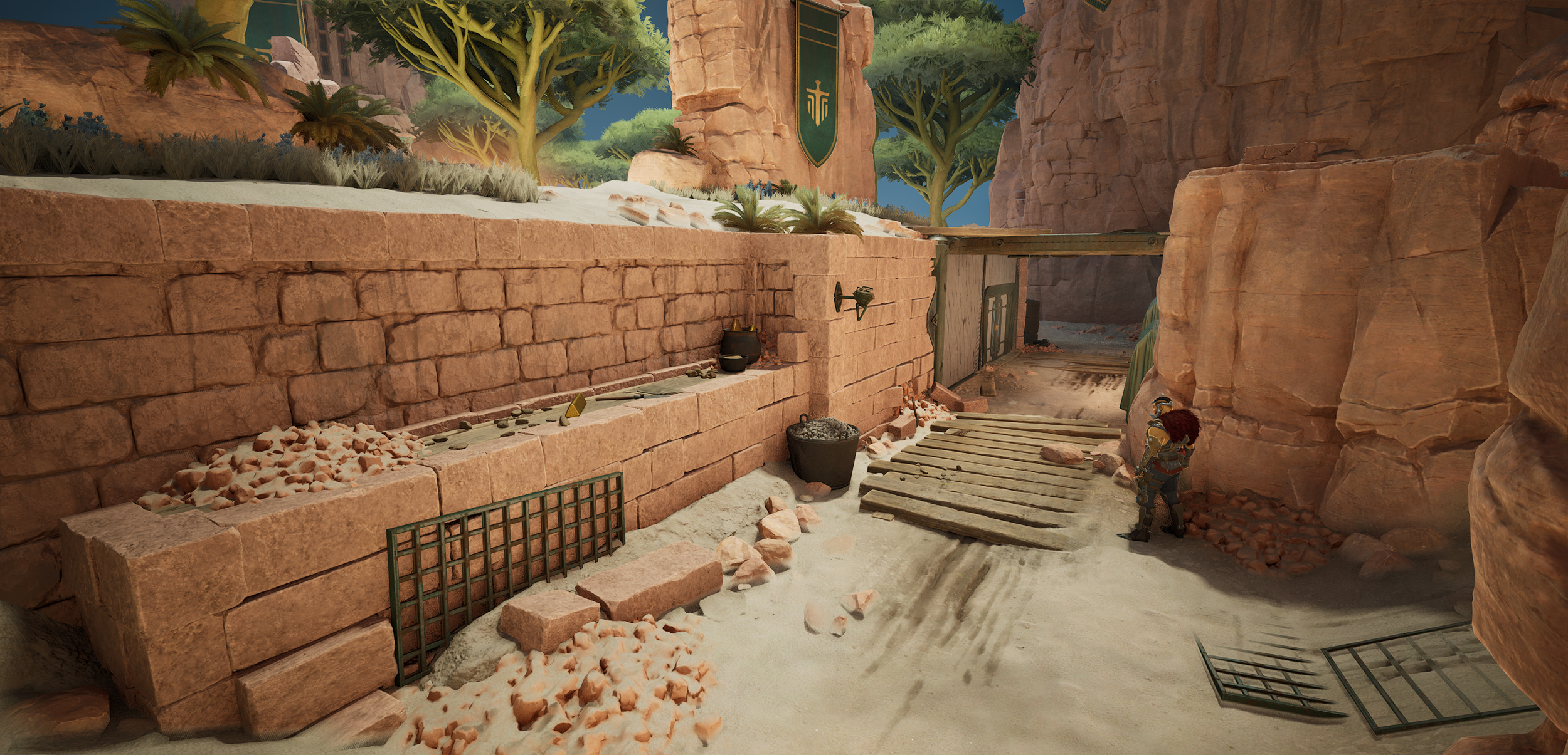 Video game scene showing a desert landscape with rocky walls, a wooden plank pathway, and two characters with armor standing near the edge of a canyon.