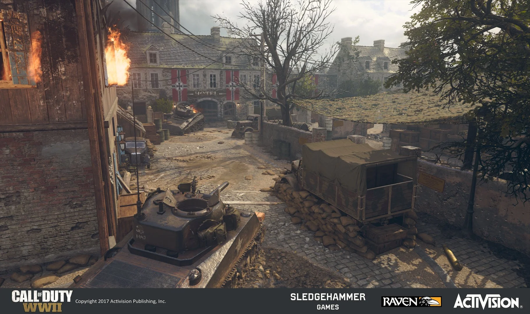 A war-torn city street scene from Call of Duty WWII, showing a burning building, damaged vehicles, sandbags, and military equipment amidst rubble and debris.
