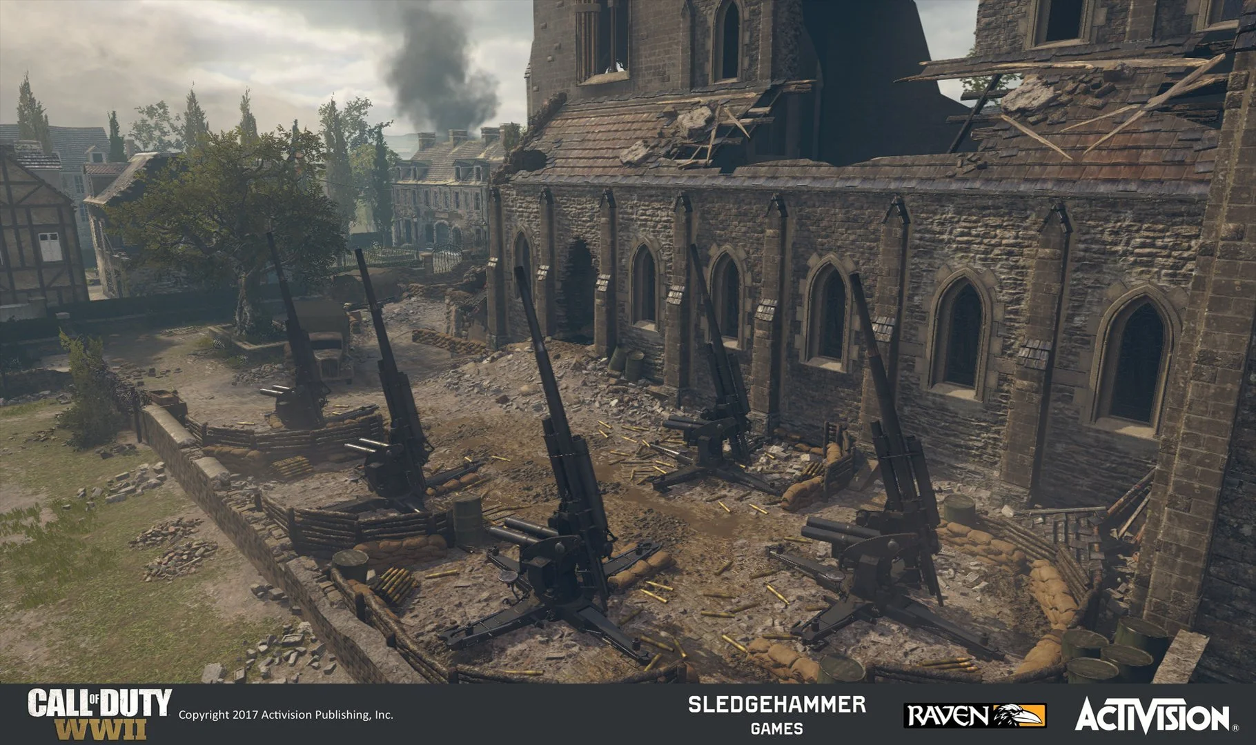 Video game screenshot of a WWII battlefield with anti-aircraft guns in front of a damaged building, with a cloudy sky and smoke in the background.