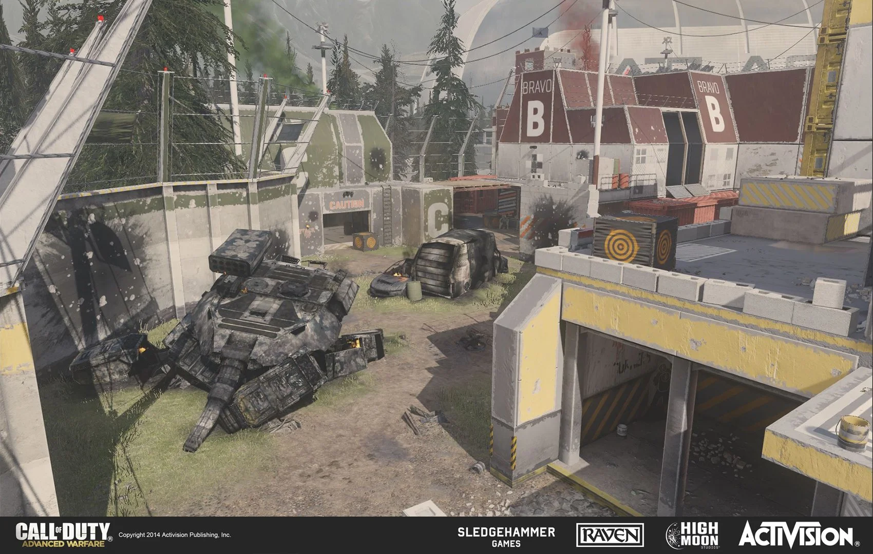 Video game scene featuring a military tank, burned cars, and a military base with buildings labeled Bravo, inside a fenced area with barbed wire.