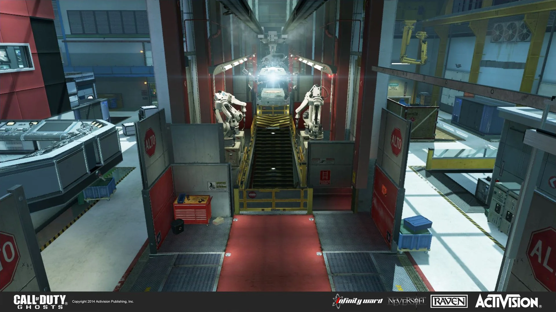 Inside a high-tech industrial facility with robotic arms working on a vehicle suspended in the air, surrounded by machinery, equipment, and safety barriers.