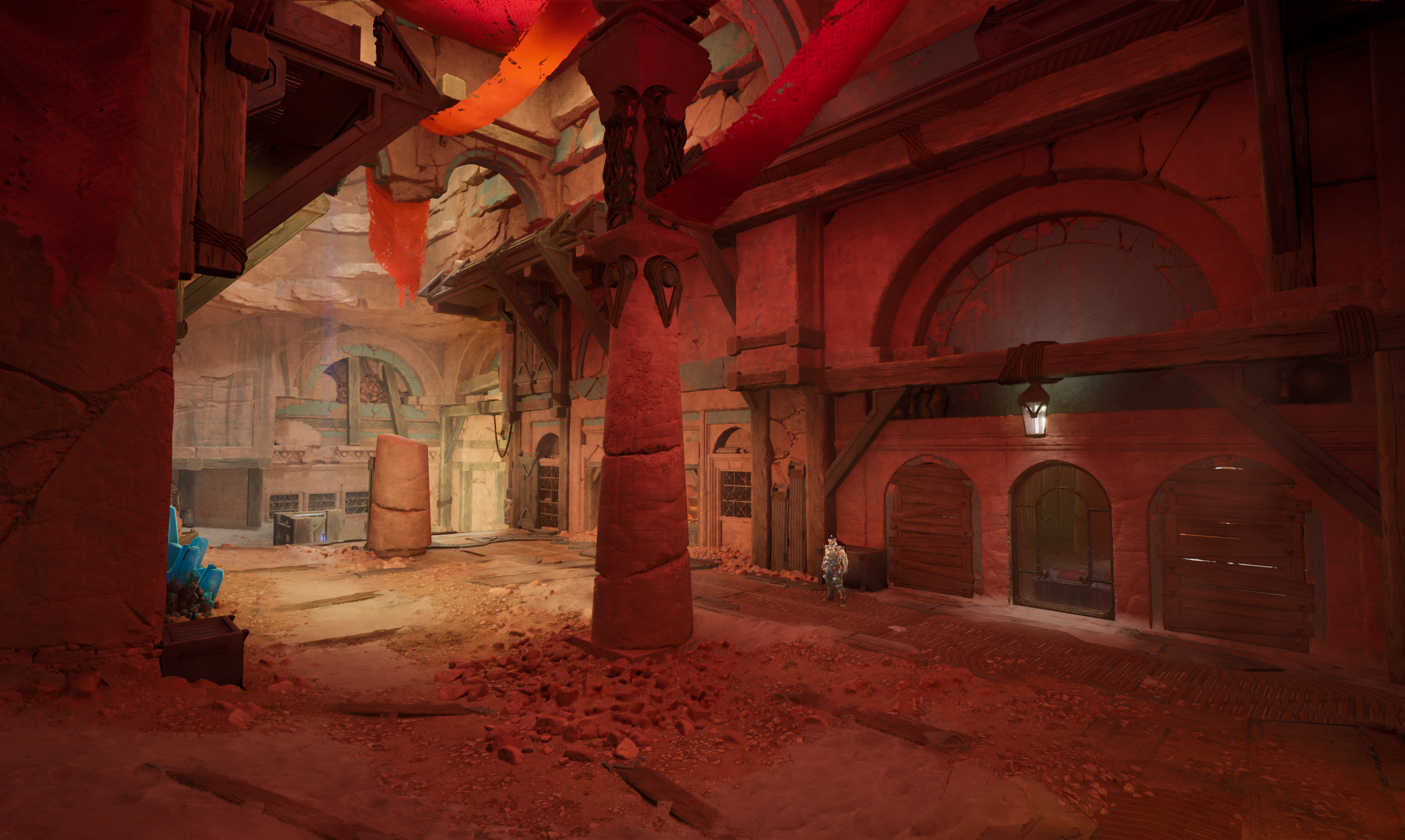 A fantasy-style indoor scene with red sandstone walls and large arches. There is a single stone pillar in the center supporting an overhanging balcony with wooden beams. The ground is rough and dusty, with rubble and debris. A small armored figure st