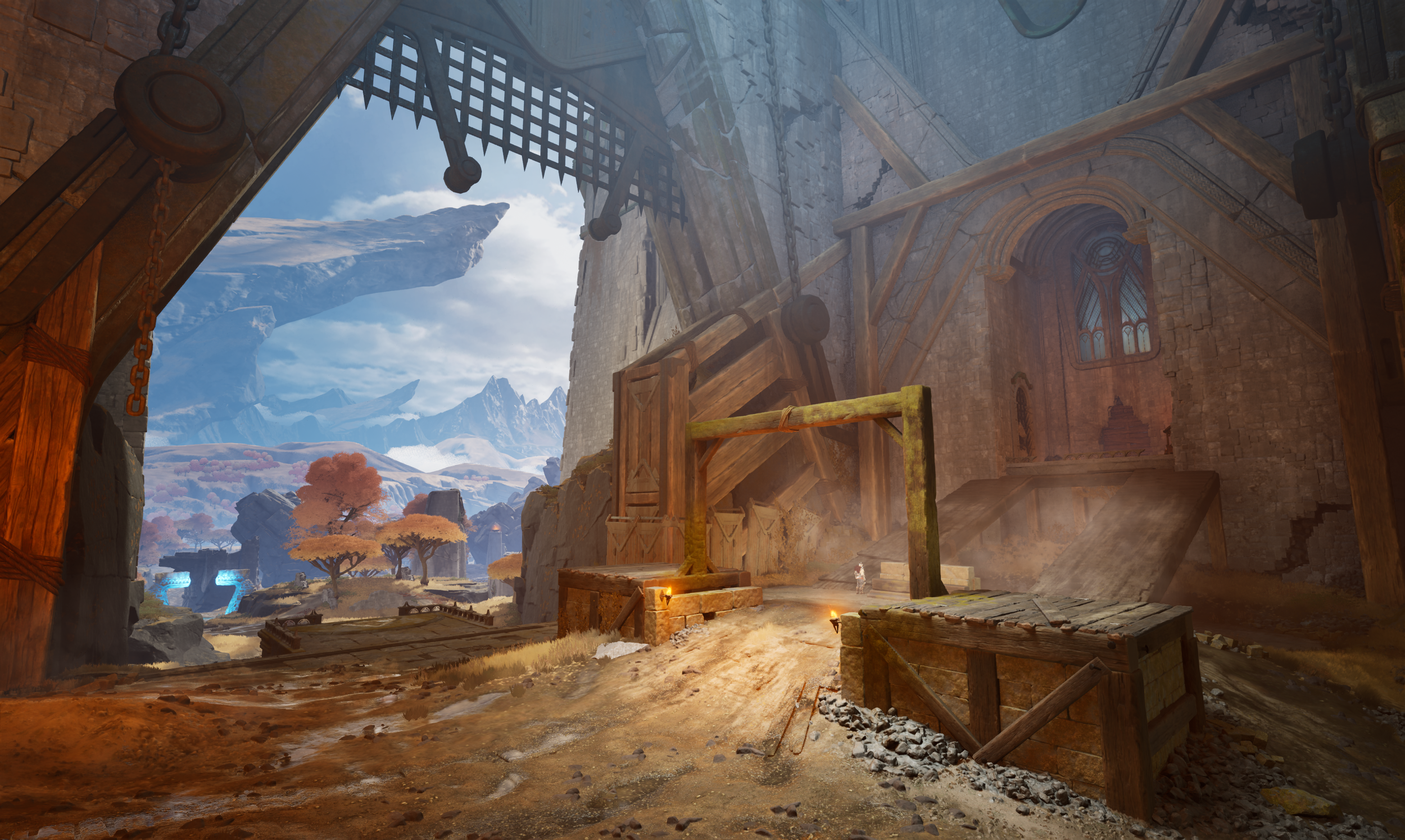 Interior of a medieval castle under construction with large stone walls, wooden scaffolding, and an open gate leading to a landscape with trees and mountains in the distance.