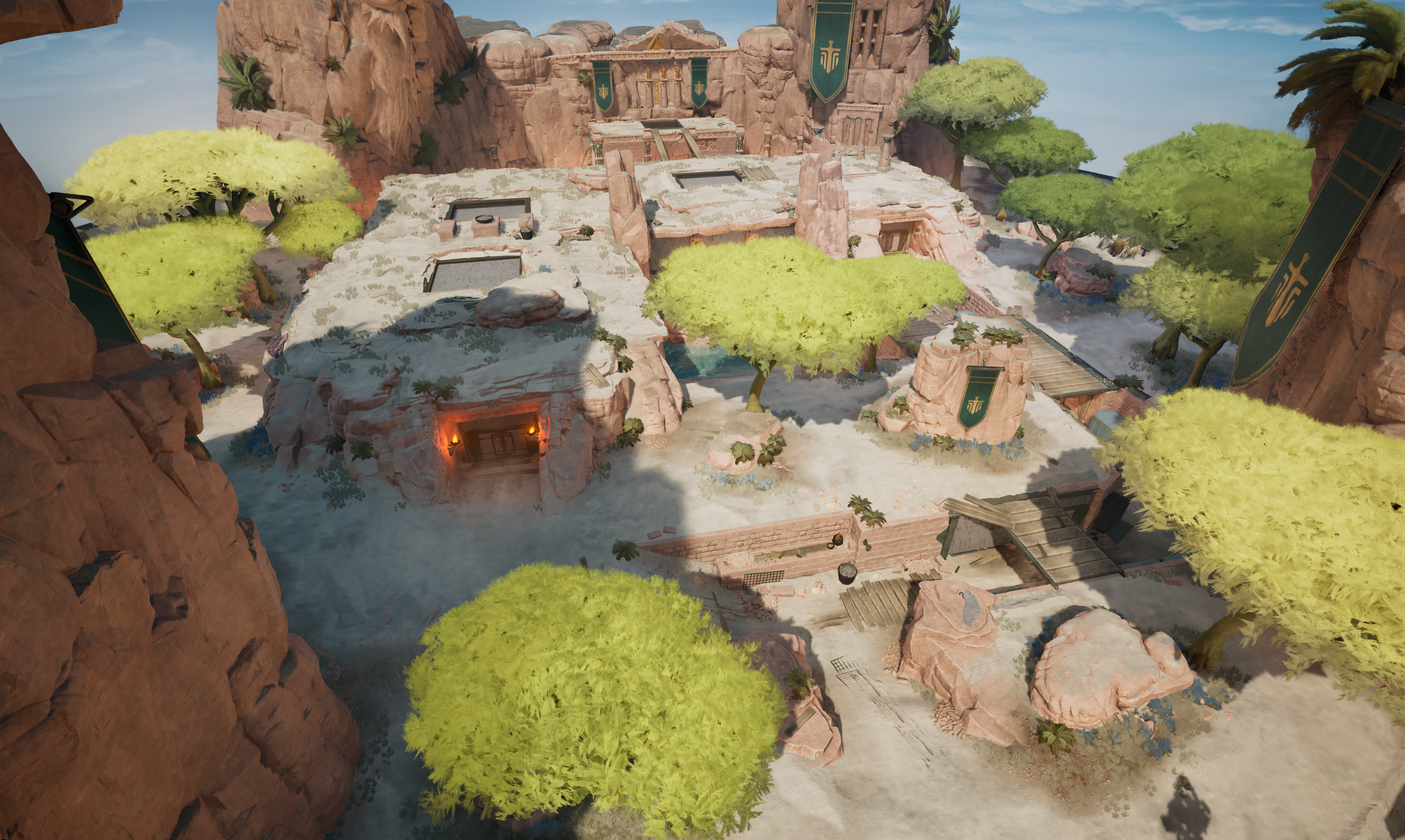 A detailed view of a virtual map known as Ilios, a Greek mythology-themed gaming environment featuring rocky cliffs, lush green trees, ancient ruins, and banners with symbols hanging from the cliffs.