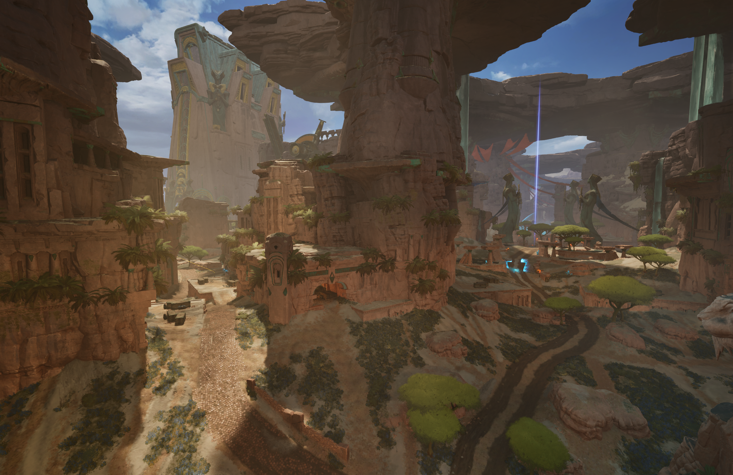 A fantasy landscape with towering rocky cliffs, ancient ruins, and large statues of robed figures holding staffs, connected by a glowing blue beam of light. There are winding paths, lush green trees, and a massive ancient structure in the background 