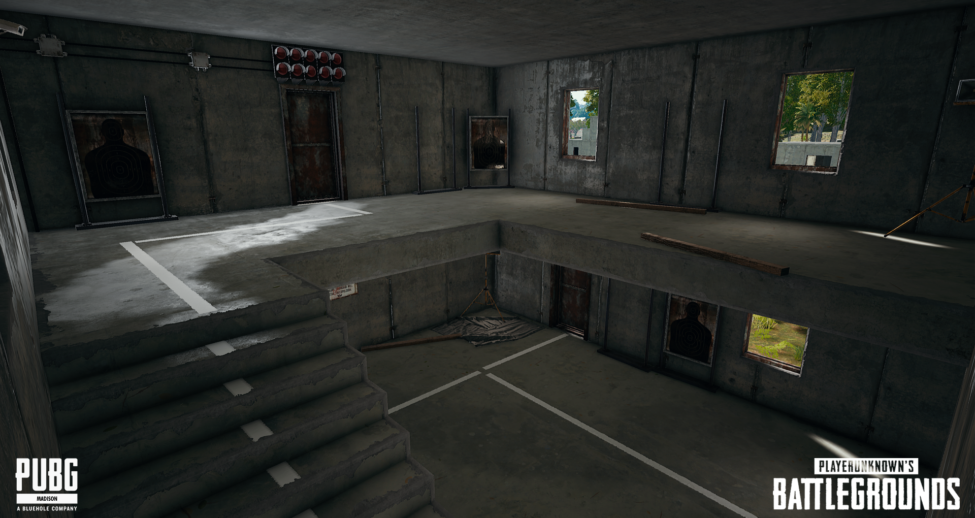 Interior of a two-story concrete building with a staircase on the left, shooting range targets on the walls, and four windows showing greenery outside. Logos for PUBG and PlayerUnknown's Battlegrounds are in the bottom corners.