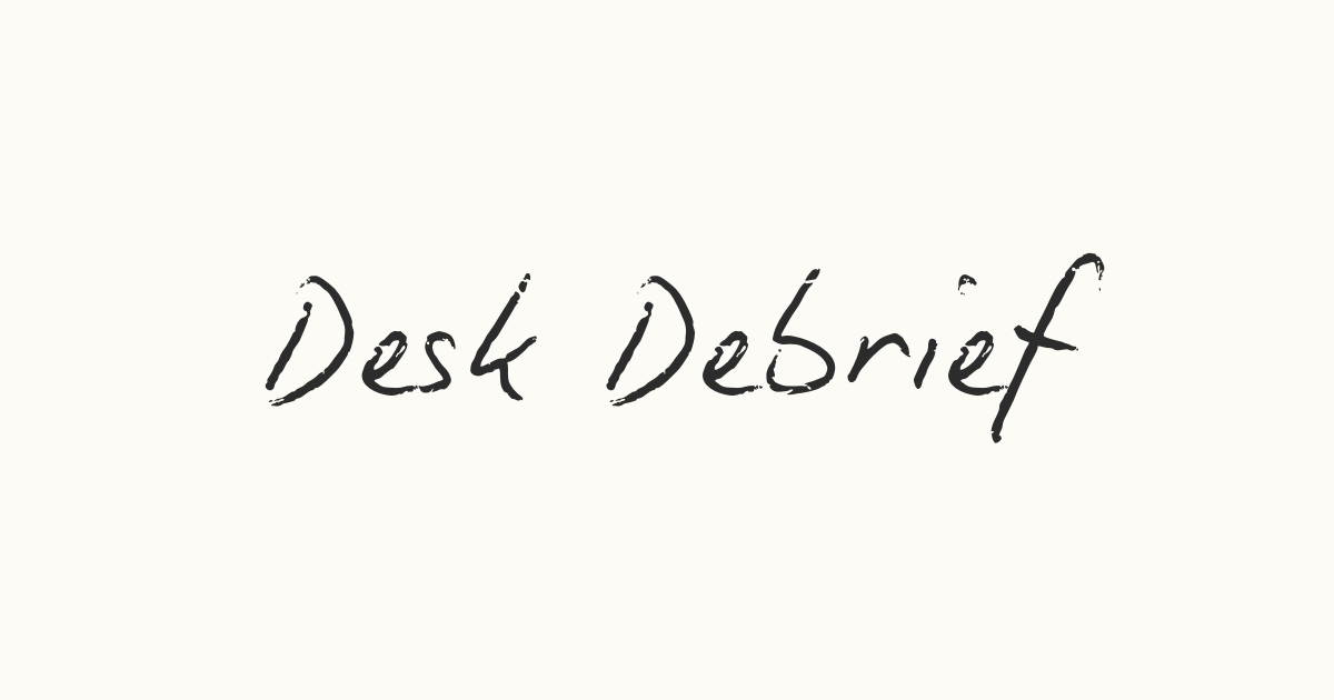 Handwritten text that reads 'Desk Debrief' on a plain white background.