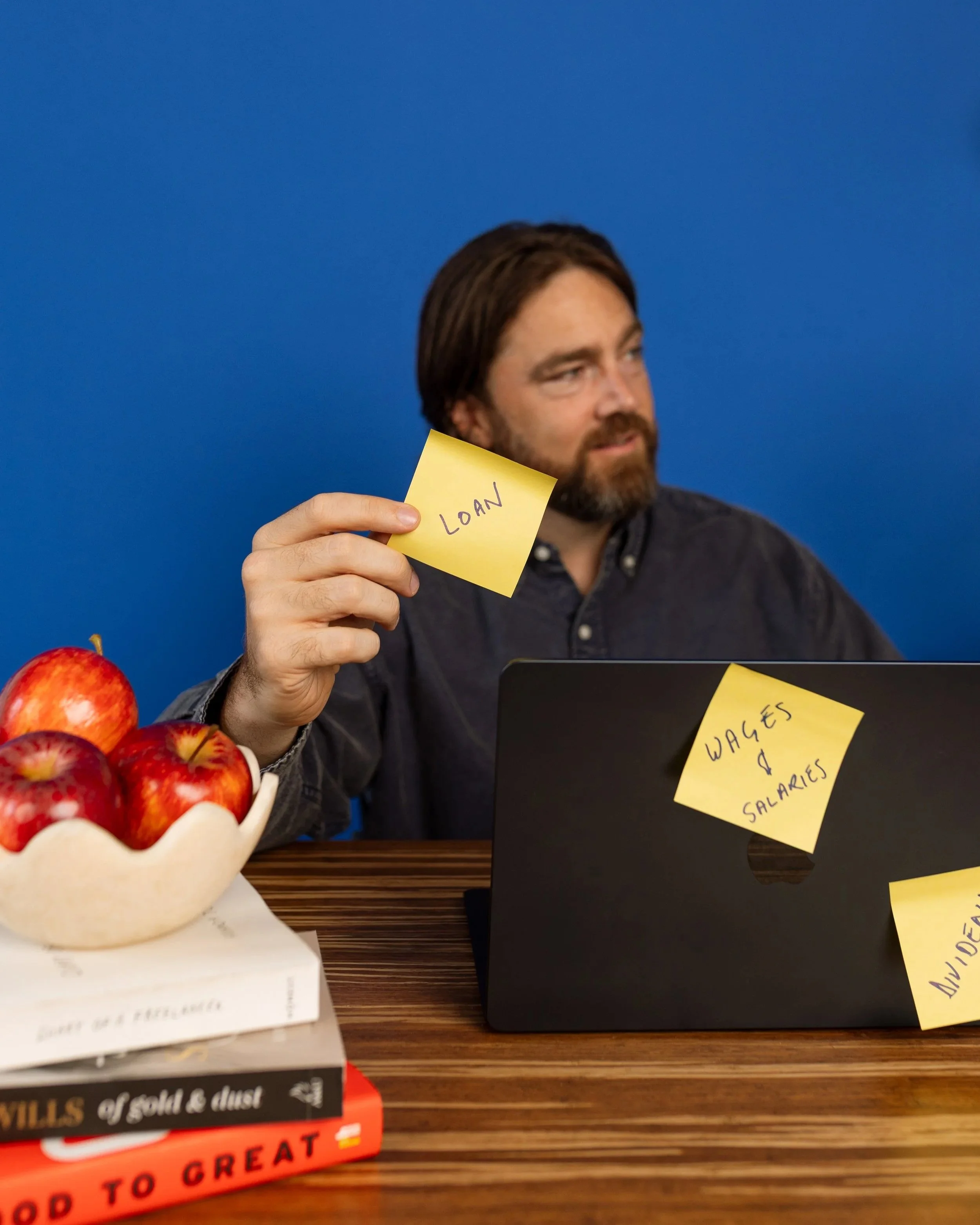 A director of an accounting business holding a post it with the word LOAN on it.