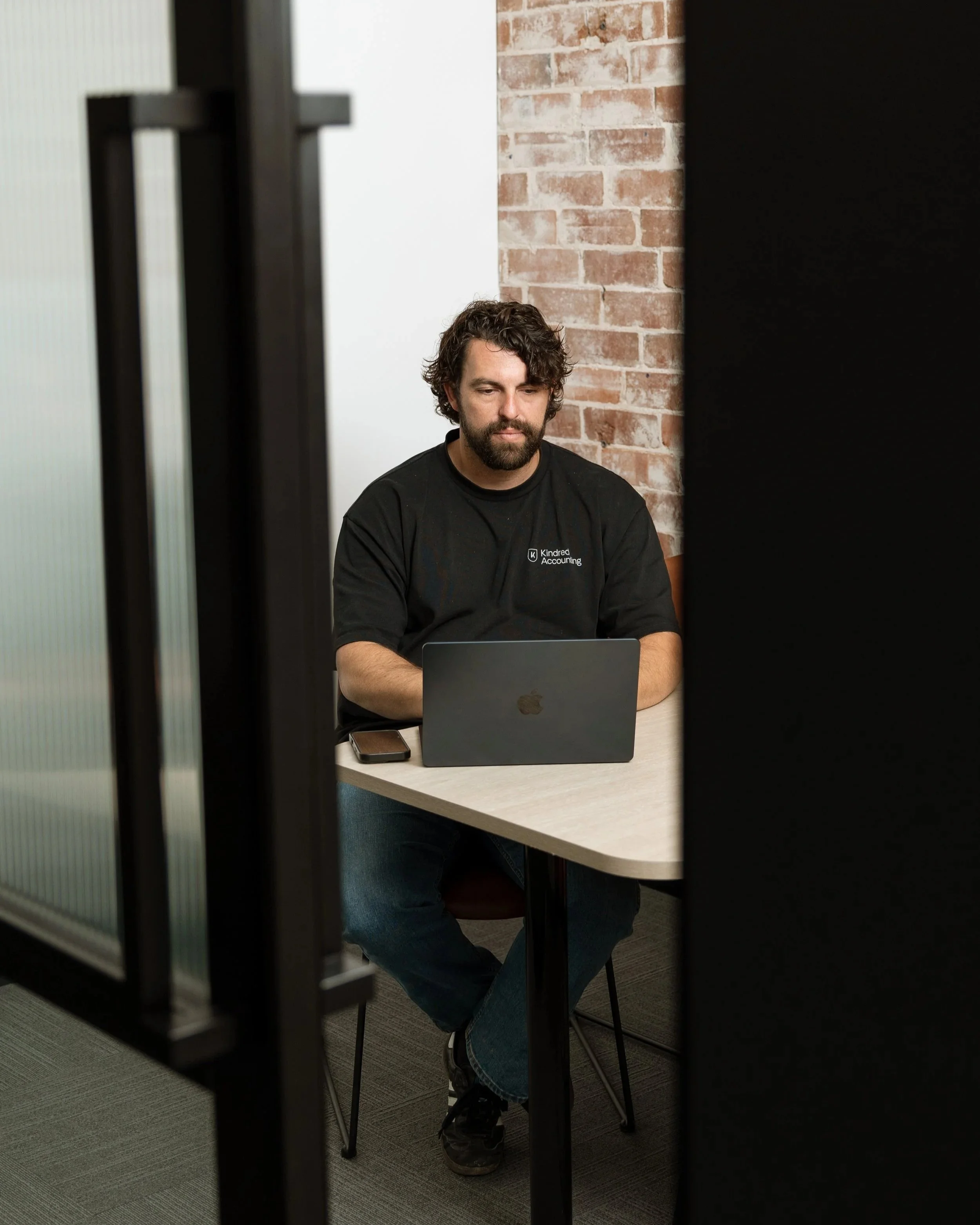 Business owner working through his numbers on a laptop at Kindred Accounting