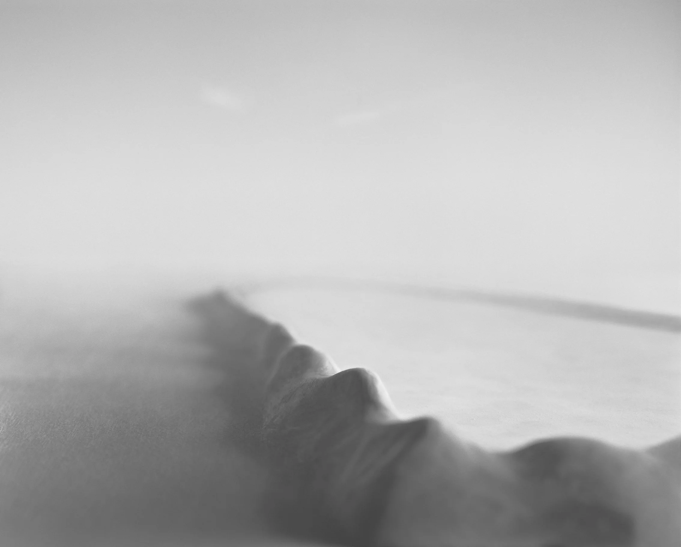 Black-and-white photograph by Nils Olav Bøe, shows a mountain range in an open landscape