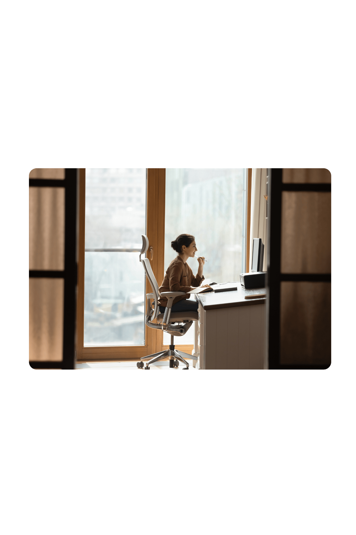Jeune femme assise de profil sur une chaise ergonmique et devant un bureau incliné avec support pour ordinateur portable pour illustrer le rôle du matériel ergonomique - Neomove
