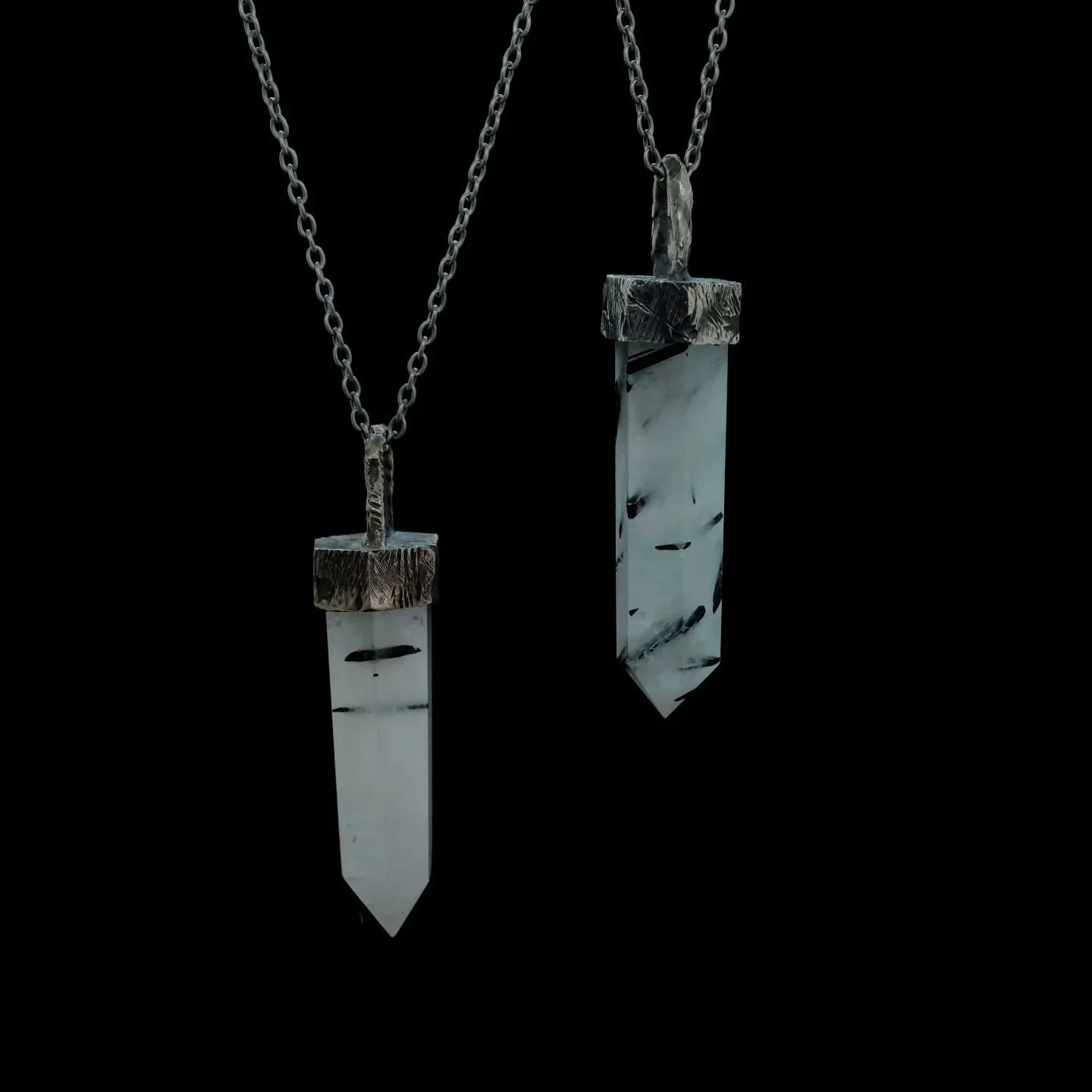 Some of our quartz pendants. More variations are available, and will be posted in the future.
Here we have a tourmalated quartz (a quite milky quartz at that).
These pendants have a unique setting shaped specifiacally on and for each crystal.
Can be 