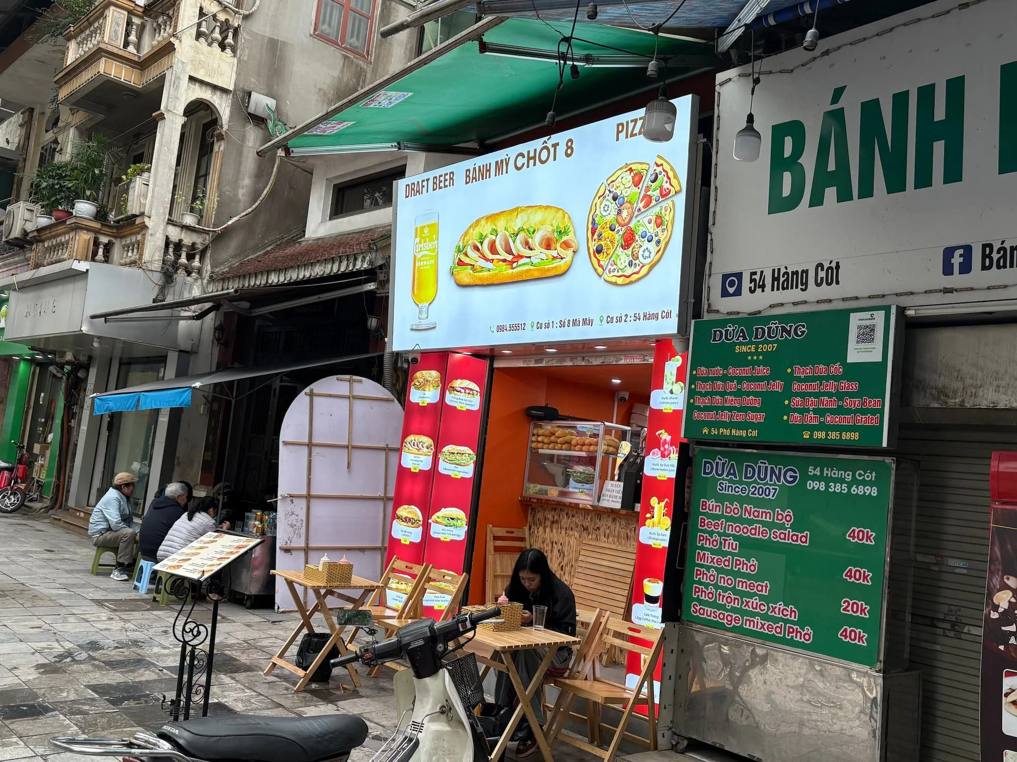 A local eating a bahn mi on the stree in Hanoi in Vietnam