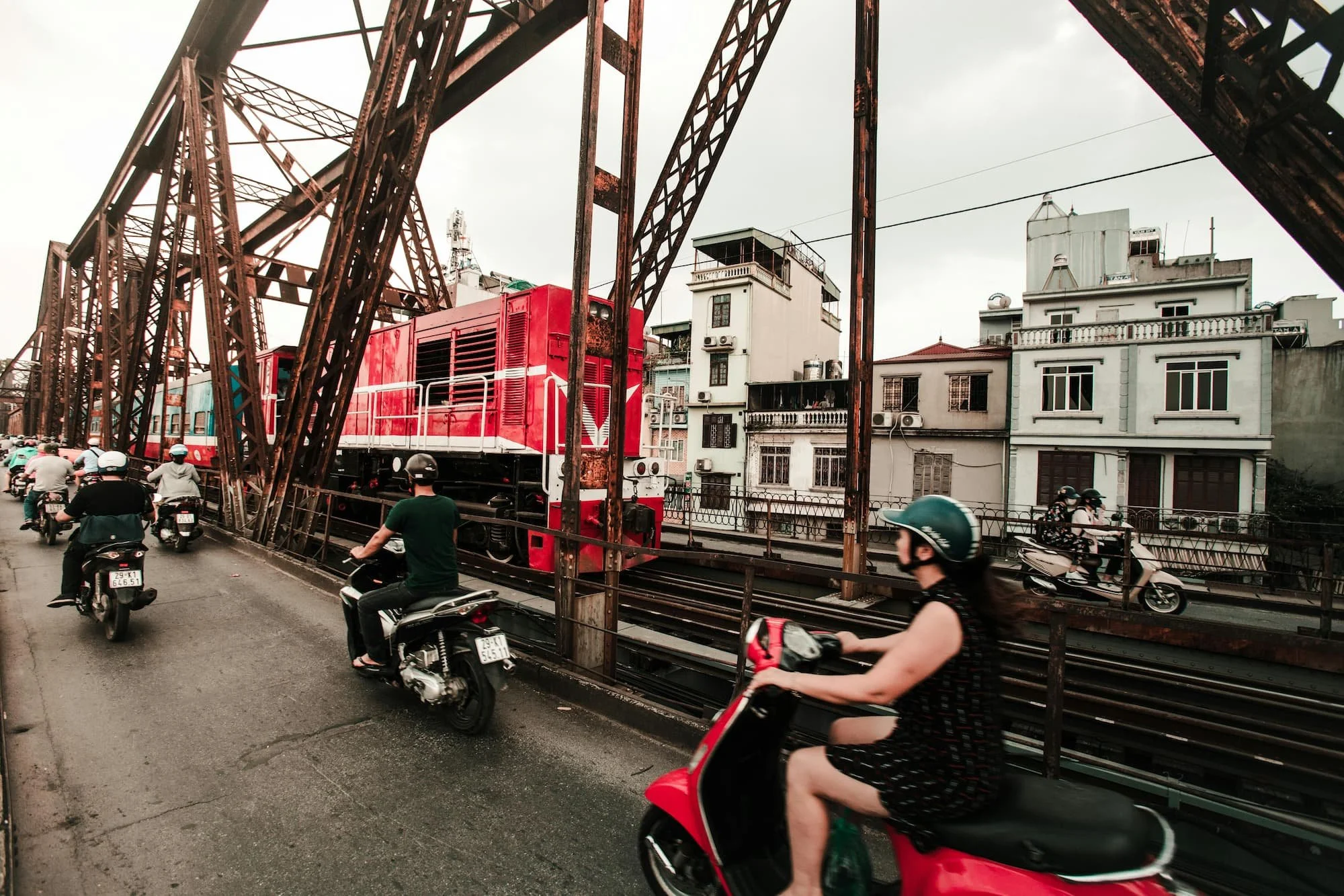 Scooters riding past a train in Hanoi in Vietnam