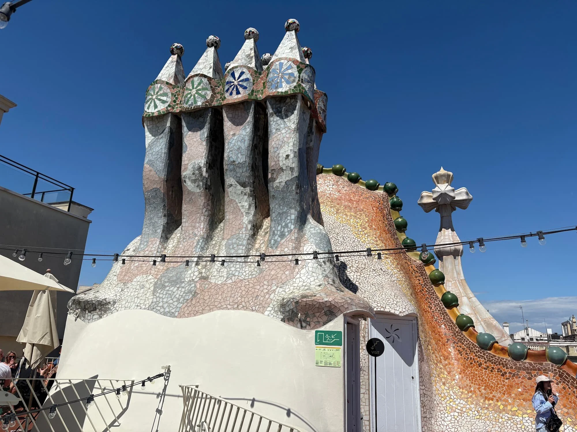 Colourful mosaic chimneys and dragon-scale rooftop details at Casa Batlló in Barcelona designed by Antoni Gaudí.