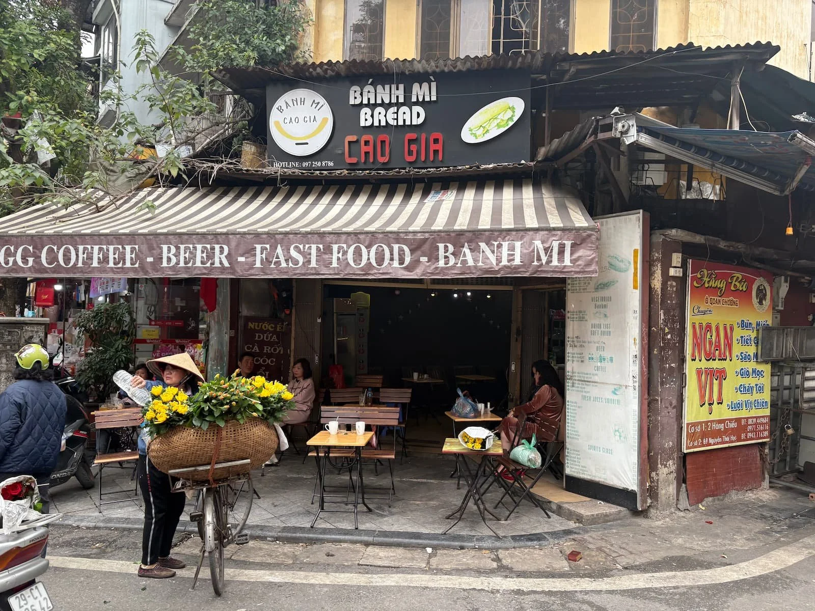 A local flower seller infront of a Bahn Mi Cafe in Hanoi