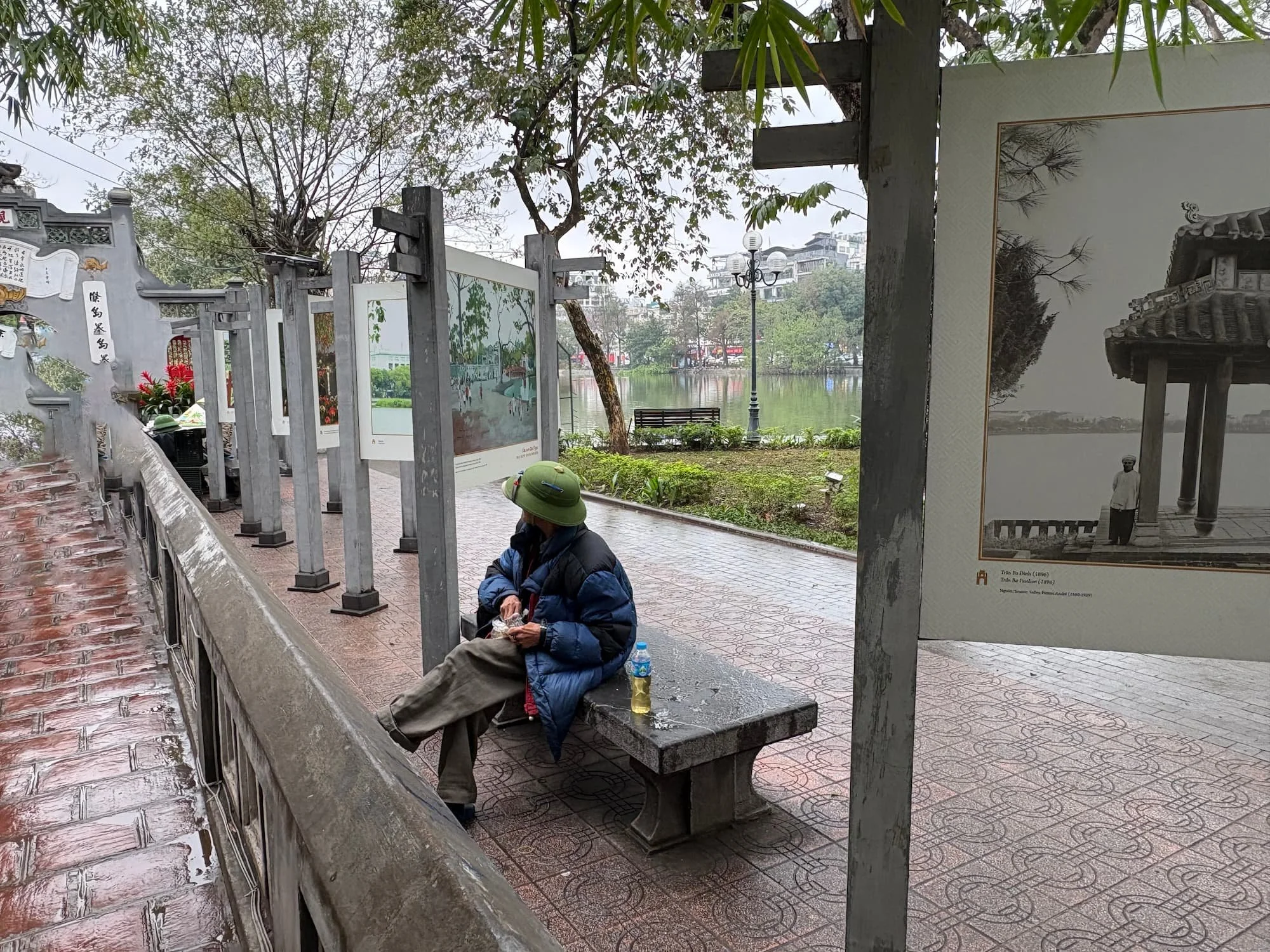 A locla person wearing a Vietnamese war helmet at a pagoda in Hanoi in Vietnam